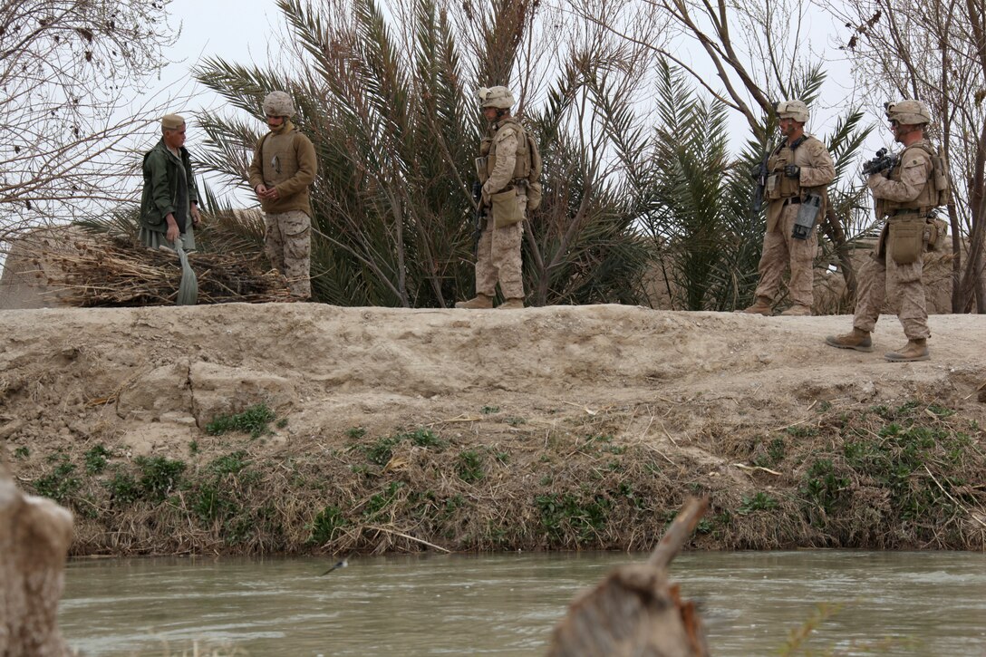 U.S. Marines with 3rd Platoon, Company I, Battalion Landing Team 3/8, 26th Marine Expeditionary Unit, Regimental Combat Team 8, and their interpreter speak to an Afghan boy at a vehicle check point at a bridge crossing the Nahr-e Saraj canal in Helmand province, Afghanistan, Feb. 27, 2011. Elements of 26th Marine Expeditionary Unit deployed to Afghanistan to provide regional security in Helmand province in support of the International Security Assistance Force.