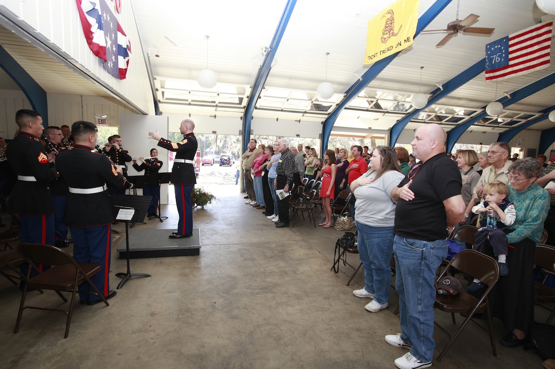 More than 100 enthusiasts stand up to honor the nation as the bandmaster, Master Sgt. Richard D. Dengler, conducts the 2nd Marine Aircraft Wing Band as it performs the National Anthem at Moores Creek National Battlefield Sunday.