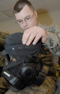 Staff Sgt. Richard Eccleston, 1st Maintenance Squadron aerospace ground equipment craftsman, inspects the outer cover and straps of his gas mask before processing through a personnel deployment function line during an Operation Readiness Exercise at Langley Air Force Base, Va, Feb. 27, 2011. Wing exercise evaluation team members assessed the 1st Fighter Wing, 633d Air Base Wing, and 192d Fighter Wing’s readiness to deploy in a short time frame. (U.S. Air Force photo by Senior Airman Antoinette Gibson/Released)