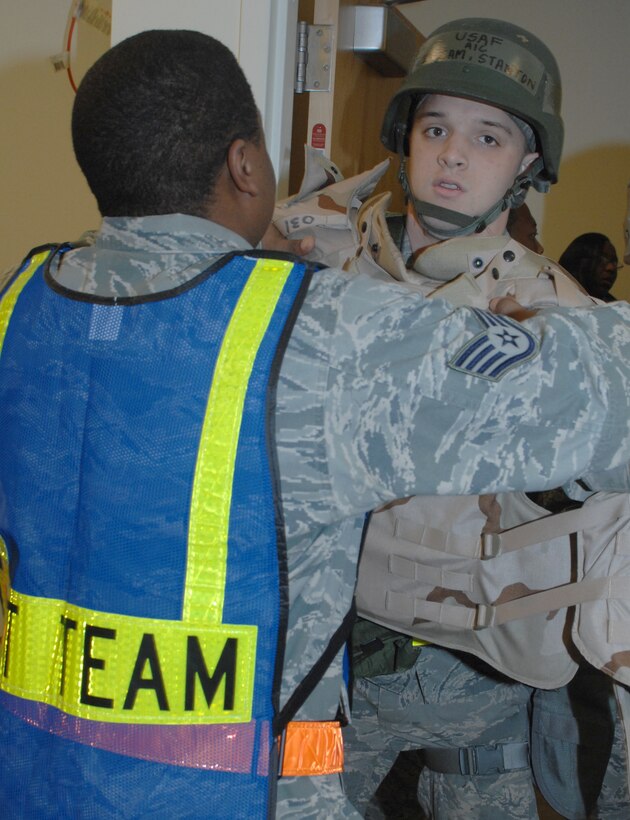 Staff Sgt. Akino Malcum, 633d Force Support Squadron air passenger transit personnel, assists Airman 1st Class William Stanton, 1st Maintenance Squadron journeyman, with his body armor to be weighed before entering a simulated aircraft during an Operation Readiness Exercise at Langley Air Force Base, Va, Feb. 27, 2011. The 1st Fighter Wing, 633d Air Base Wing, and 192d Fighter Wing participated in a two-day ORE testing wings’ readiness in case of a disaster, imminent terrorist or enemy threat, and short-notice orders to deploy.(U.S. Air Force photo by Senior Airman Antoinette Gibson/Released)

