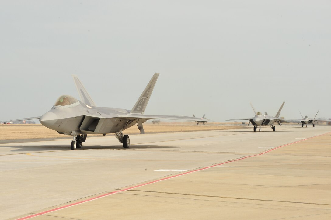 F-22A Raptors taxi down a runway at Langley Air Force Base, Va, Feb. 27, 2011.   Part of a two -day exercise, Langley Airmen from the 633d Air Base Wing, 1st Fighter Wing and 192nd Fighter Wing worked together to practice deploying people, equipment and aircraft for contingency operations on short notice.  (U.S. Air Force photo by Staff Sgt. Logan Tuttle/Released)
