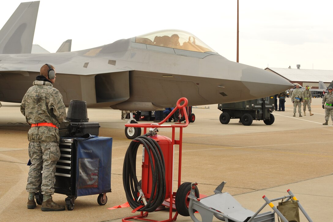 Airman 1st Class Nicholas Russell, 94th Aircraft Maintenance Unit F-22A Raptor crew chief, watches an F-22 as it prepares to move to a runway at Langley Air Force Base , Va, Feb.  27, 2011.  Airman Russell helped launch the first jet to take off during a two-day exercise in which 633rd Air Base Wing, 1st Fighter Wing and 192nd Fighter Wing members practiced deploying on short notice.  (U.S. Air Force photo by Staff Sgt. Logan Tuttle/Released)