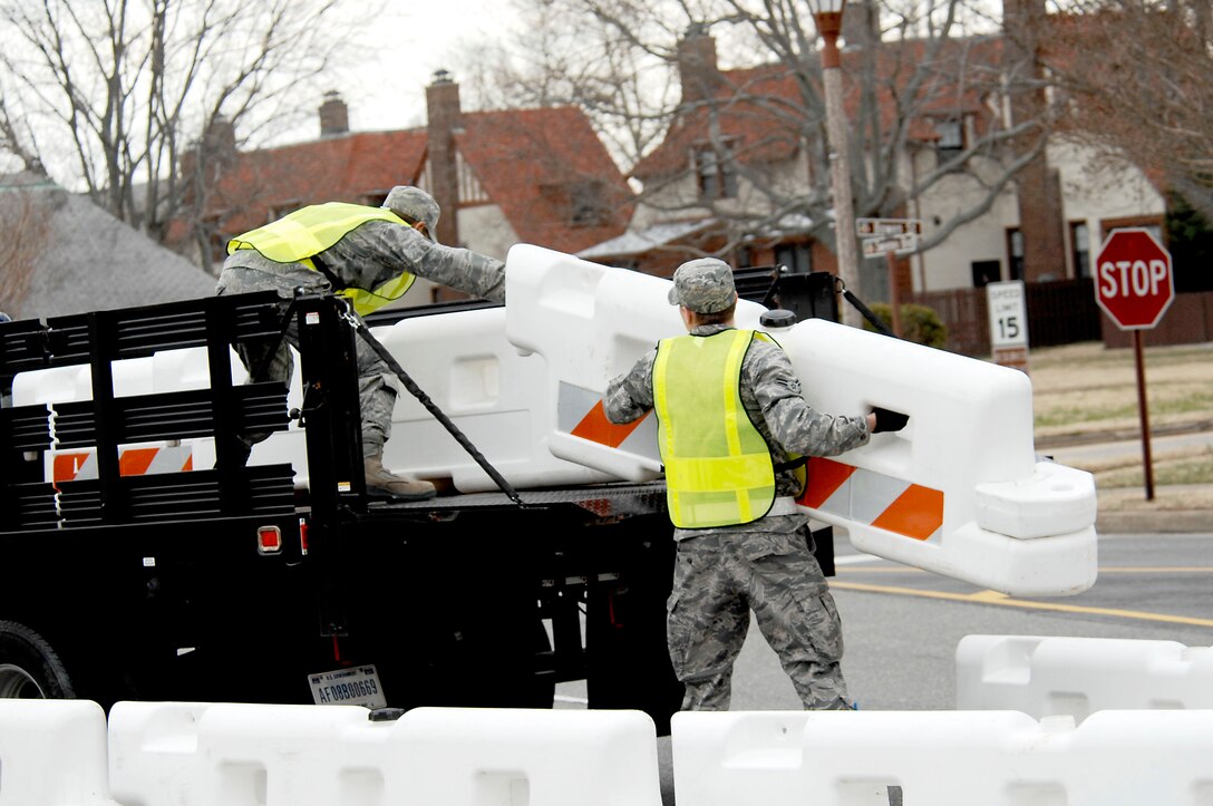 Airman 1st Class Aaron Cain, 633d Civil Engineer Squadron, loads a barrier onto a truck with Airman 1st Class Robert Sorreano, 633d Civil Engineer Squadron structural apprentice, during an Operational Readiness Exercise at Langley Air Force Base, Va., Feb. 27, 2011.  Members of the 633d Air Base Wing, 1st Fighter Wing, and 192nd Fighter Wing are tested on their ability to deploy Airmen, cargo, and aircraft on a short notice.  (U.S. Air Force photo by Airman 1st Class Kayla Newman/Released)