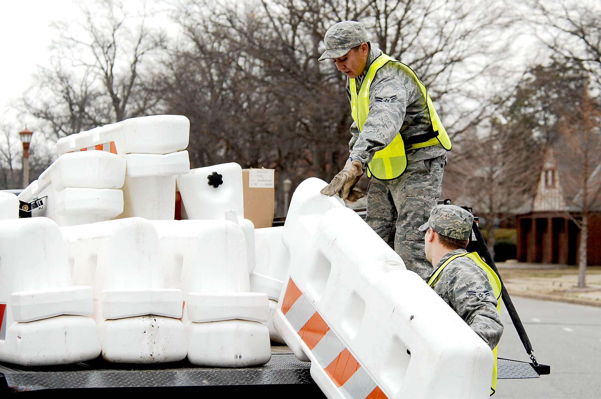 Airman 1st Class Aaron Cain and Airman 1st Class Robert Sorreano, 633d Civil Engineer Squadron, remove a barrier at Langley Air Force Base, Va., Feb. 27, 2011.  The barriers were put up as part of a two-day Operational Readiness Exercise used to test the 633d Air Base Wing, 1st Fighter Wing, and 192nd Fighter Wings’ ability to deploy Airmen, cargo, and aircraft on a short notice.  (U.S. Air Force photo by Airman 1st Class Kayla Newman/Released)