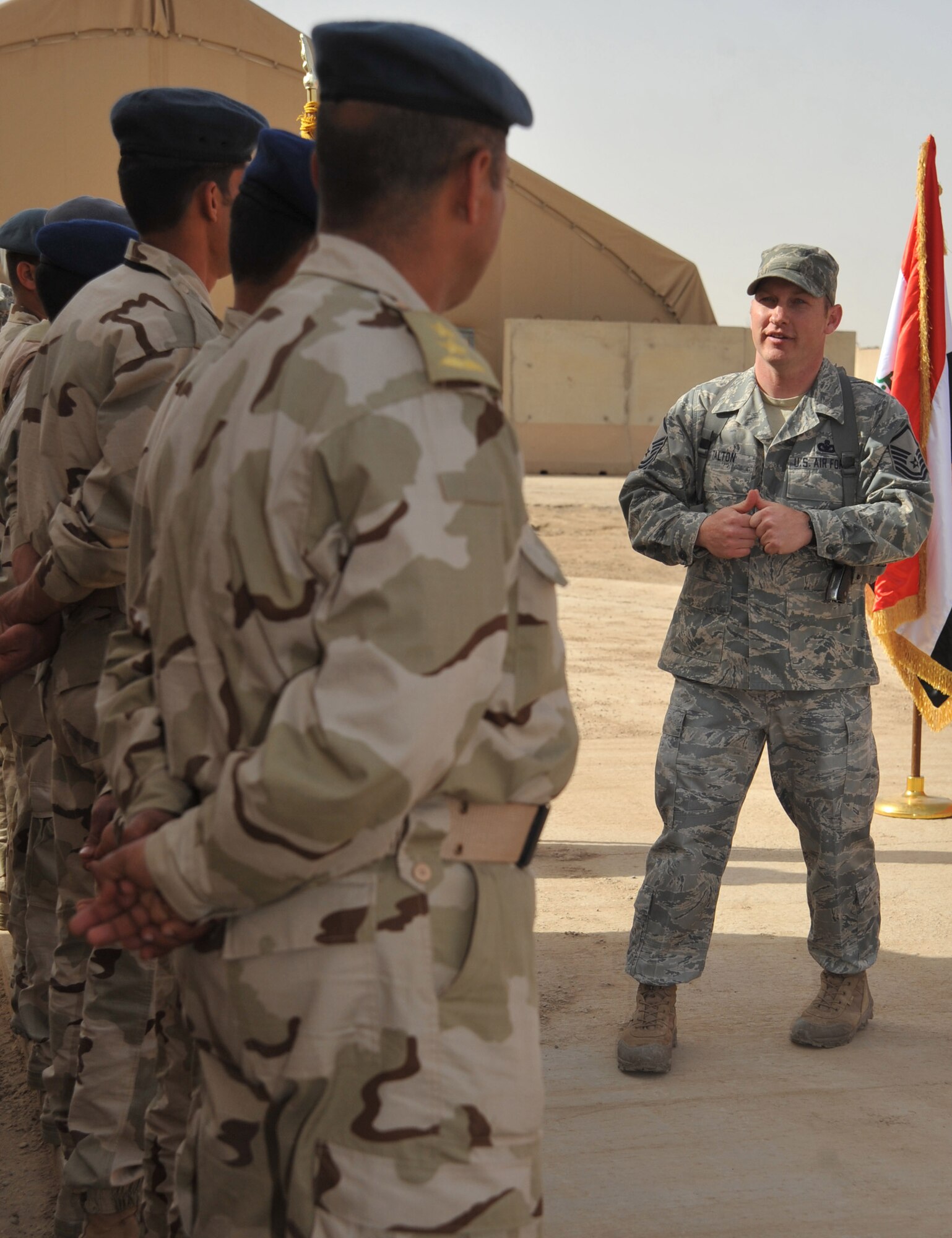 Master Sgt. Travis Talton, an Iraq Training and Advisory Mission - Air security forces advisor, speaks to the first group of Iraqi defenders during a graduation ceremony Feb. 22, 2011, at Ali Air Base, Iraq. The Iraqi airmen completed two weeks of security forces training, including written and practical exams, held by ITAM – Air advisors and members of the 407th Expeditionary Security Forces Flight. (U.S. Air Force photo by Senior Airman Andrew Lee/Released) 