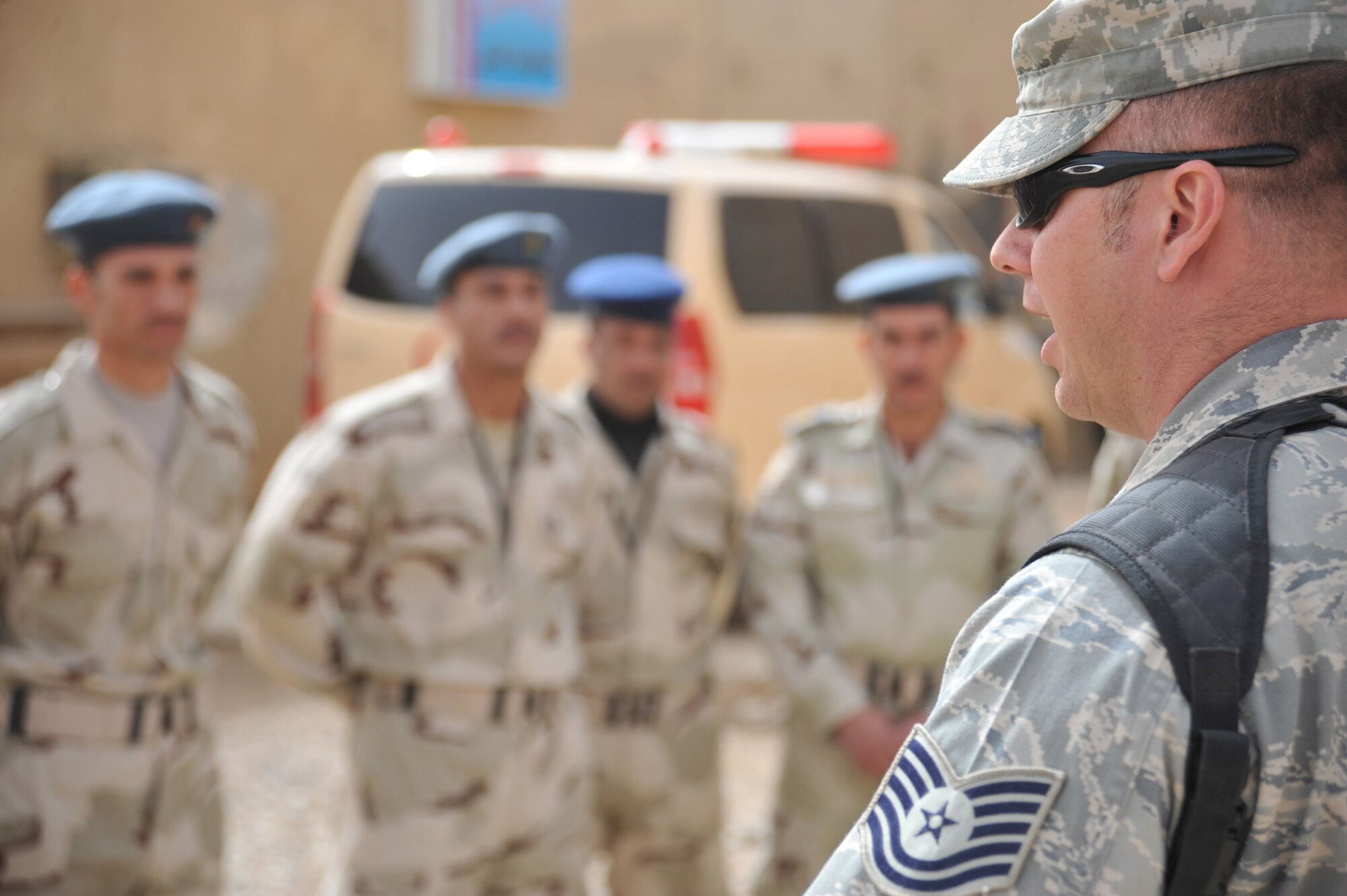 Tech. Sgt. Ricky Furrow, an Iraq Training and Advisory Mission - Air security forces advisor and Houston, Texas, native, talks to Iraqi Air Force airmen about their next challenge during a security forces training session held by ITAM – Air advisors and members of the 407th Expeditionary Security Forces Flight Feb. 21, 2011, at Ali Air Base, Iraq.  (U.S. Air Force photo by Senior Airman Andrew Lee/Released) 