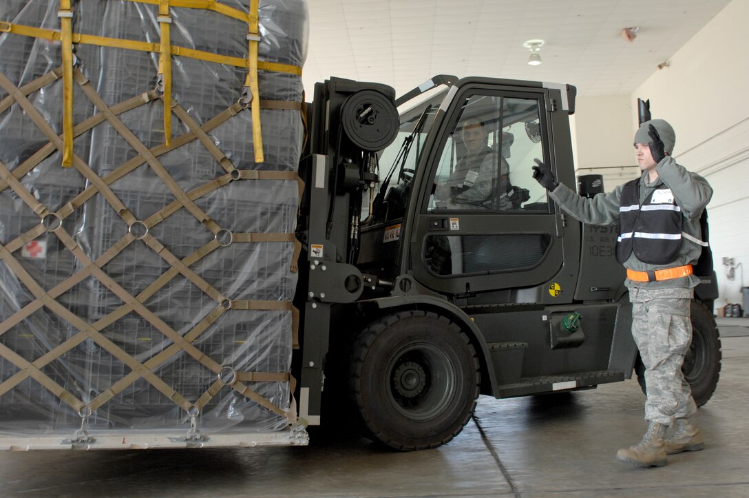 Senior Airman Ryan Sandmeier, member of the cargo movement team and Airman 1st Class Casey Snyder, material handling equipment operator, 633d Air Base Wing Logistic Readiness Squadron process cargo during a two-day operational readiness exercise at Langley Air Force Base, Va Feb. 26, 2011. This movement team was in charge of weighing and inspecting cargo to ensure it met the standards before simulating loading it on an aircraft. (U.S. Air Force photo by Senior Airman Antoinette Gibson/Released)