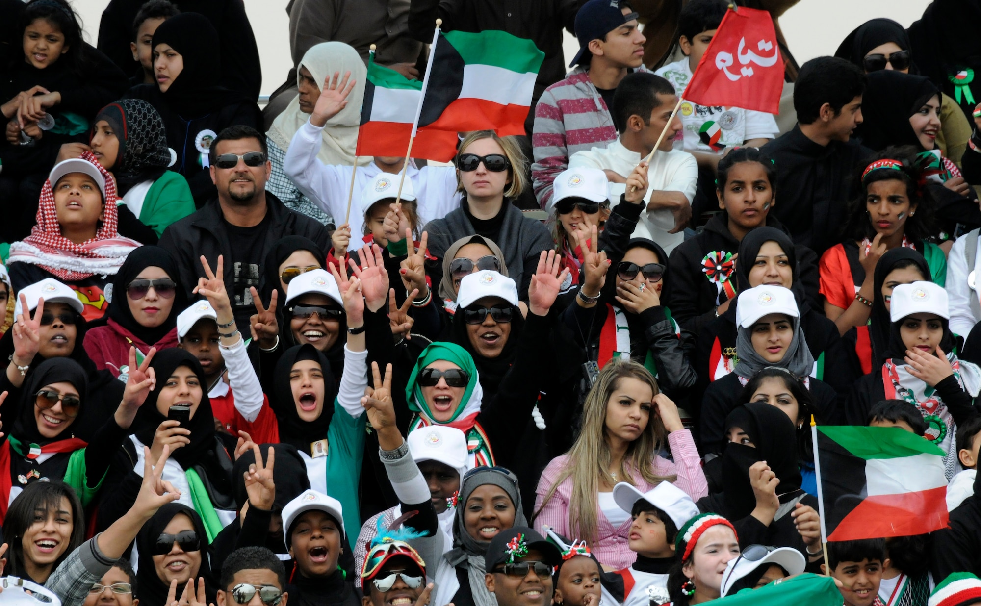 Citizens of Kuwait cheer during a parade to celebrate the nation's 50th anniversary of its liberation from Great Britain and 20th anniversary of its liberation from Iraq. The 386th Air Expeditionary Wing participated with ground-to-air communications support for the air demonstration as well as provided a flyby with one of its C-130H Hercules. (U.S. Air Force photo by Capt. Heath Allen)
