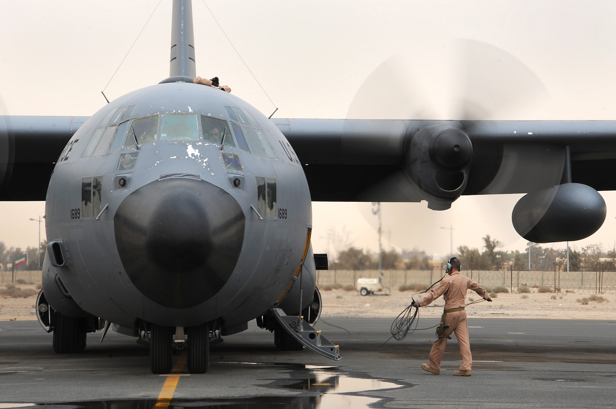 Senior Airman Joseph Mongarella, a loadmaster with the 737th Expeditionary Airlift Squadron, watches engines start during aircraft preparations just before takeoff for Kuwait's 50/20 celebration parade Feb. 26. The parade commemorated Kuwait's 50th anniversary of its independence and the 20th anniversary of its liberation which happened as a result of Operation Desert Storm. (U.S. Air Force photo by Senior Airman Cynthia Spalding)