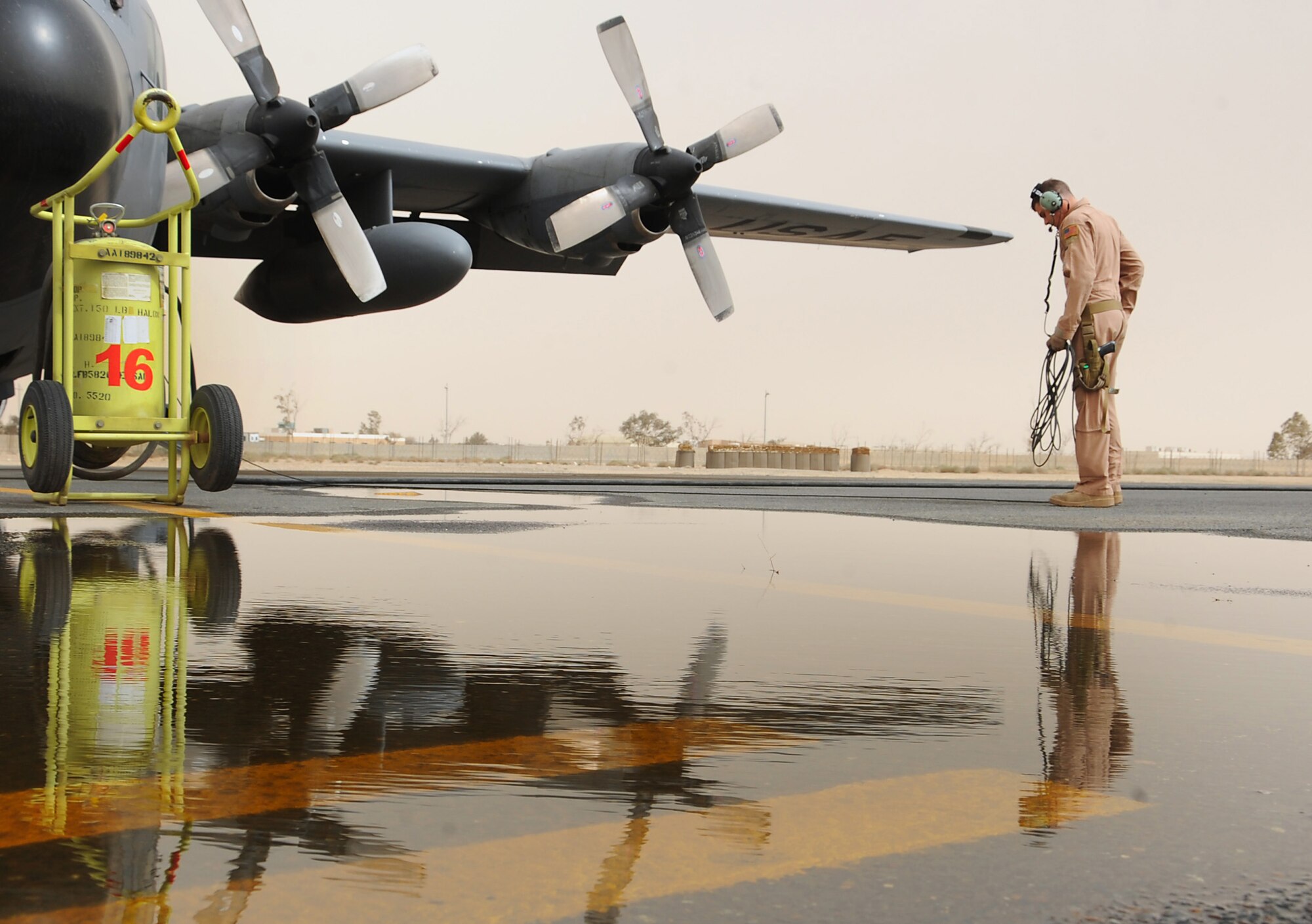 Senior Airman Joseph Mongarella, a loadmaster with the 737th Expeditionary Airlift Squadron, waits for engines to start during aircraft preparations just before takeoff for Kuwait's 50/20 celebration parade Feb. 26. The parade commemorated Kuwait's 50th anniversary of its independence and 20th anniversary of its liberation which happened as a result of Operation Desert Storm. (U.S. Air Force photo by Senior Airman Cynthia Spalding)