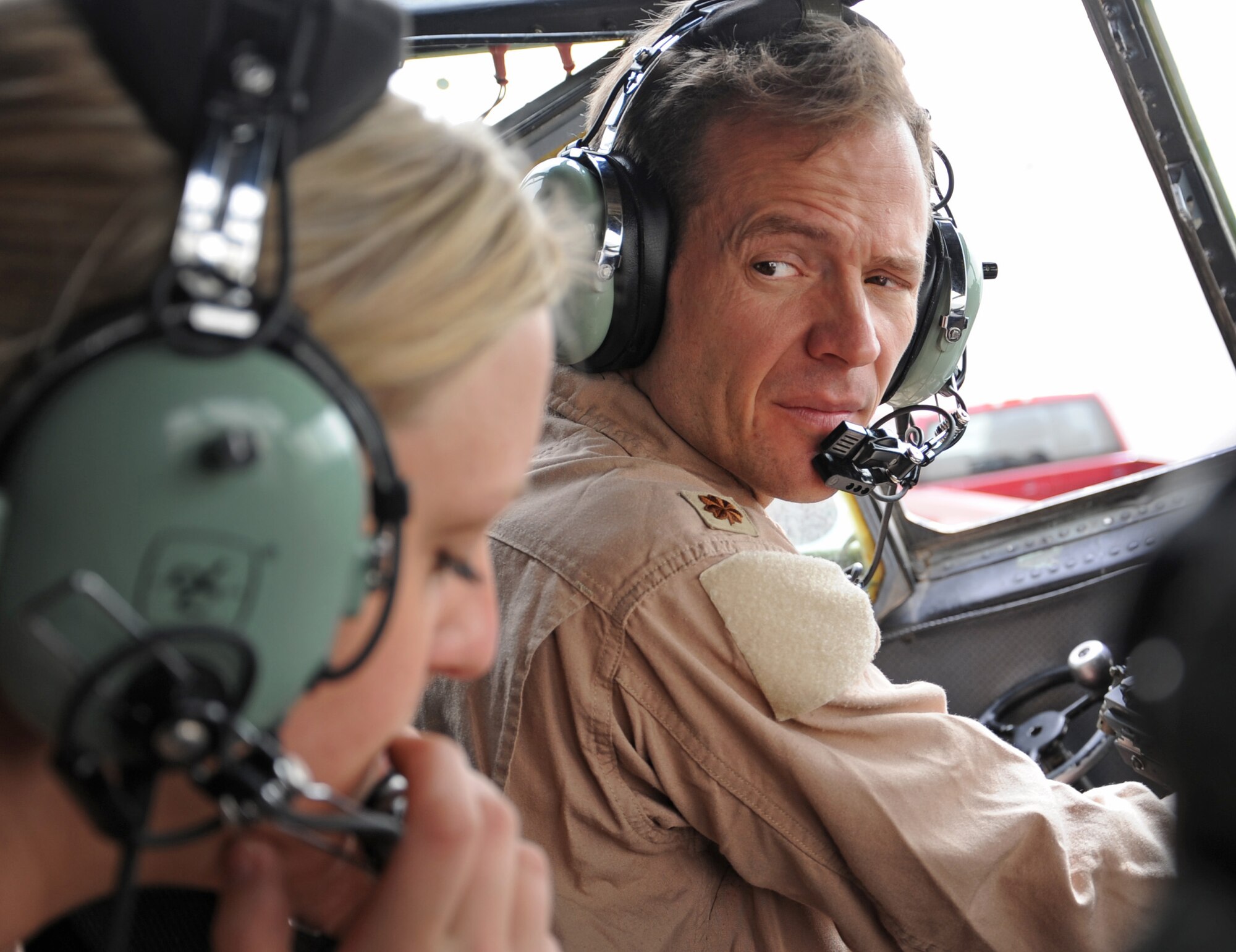 Maj. Timothy Townsend, C-130H pilot with the 737th Expeditionary Airlift Squadron, talks with Staff Sgt. Sarah Parsley, a flight engineer, just before takeoff for Kuwait's 50/20 celebration parade Feb. 26. The parade commemorated Kuwait's 50th anniversary of its independence and 20th anniversary of its liberation which happened as a result of Operation Desert Storm. (U.S. Air Force photo by Senior Airman Cynthia Spalding)