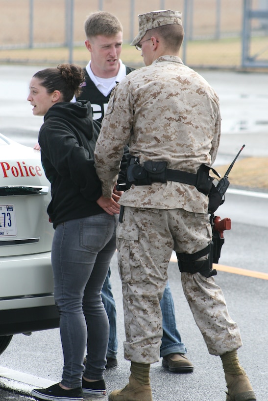 Lance Cpl. Ashley Mizrahi is placed in handcuffs by Lance Cpl. Mitchel Mertz as part of a suspicious person simulation for::r::::n::exercise Active Shield 2011 here Monday.