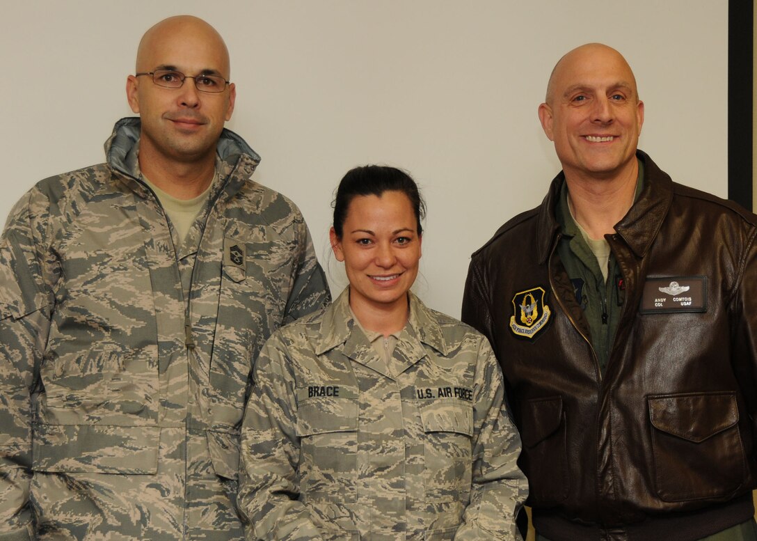 Master Sgt. Nikki Brace, 919th Communications Squadron, poses for a photo with Chief Master Sgt. Michael Klausutis, 919th Special Operations WIng command chief, left, and Col. Andy Comtois, 919th SOW commander, after they informed her of her selection as the wing's 2010 Senior NCO of the Year.  The senior leaders traveled to four different work centers to surprise the winners of the Airman, NCO, senior NCO and first sergeant categories. (U.S. Air Force photo/Tech. Sgt. Samuel King Jr.)