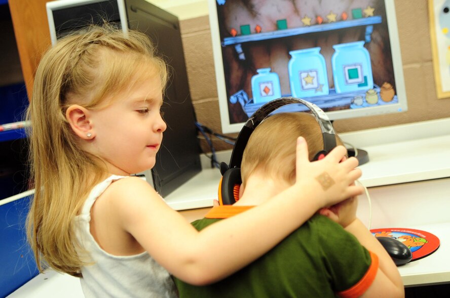 Macaela Reese, 4, helps her brother Bishop, 1, put on headphones while playing on a children’s computer at the Base Library located on Barksdale Air Force Base, La., Feb. 28. The library offers a parent computer area featuring two computers – one for parents and one child-friendly computer with various educational games. Macaela and Bishop are the children of Staff Sgt. Joshua Reese, 2nd Maintenance Squadron. (U.S. Air Force photo/Senior Airman Joanna M. Kresge)(RELEASED)