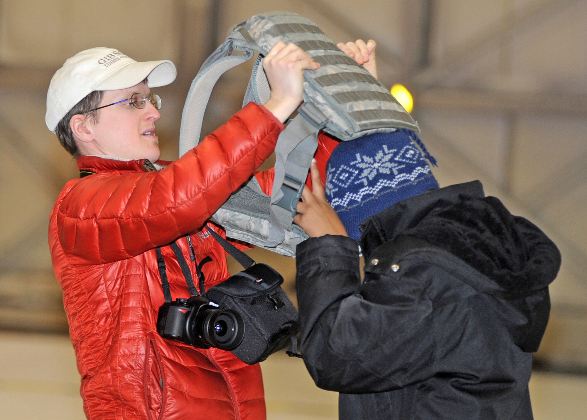 Mathew Olson, a BBBS volunteer, helps his little brother, Jeriah Coleman, try on a flak jacket during a base tour. (U.S. Air Force photo/Senior Airman Laura Turner)
