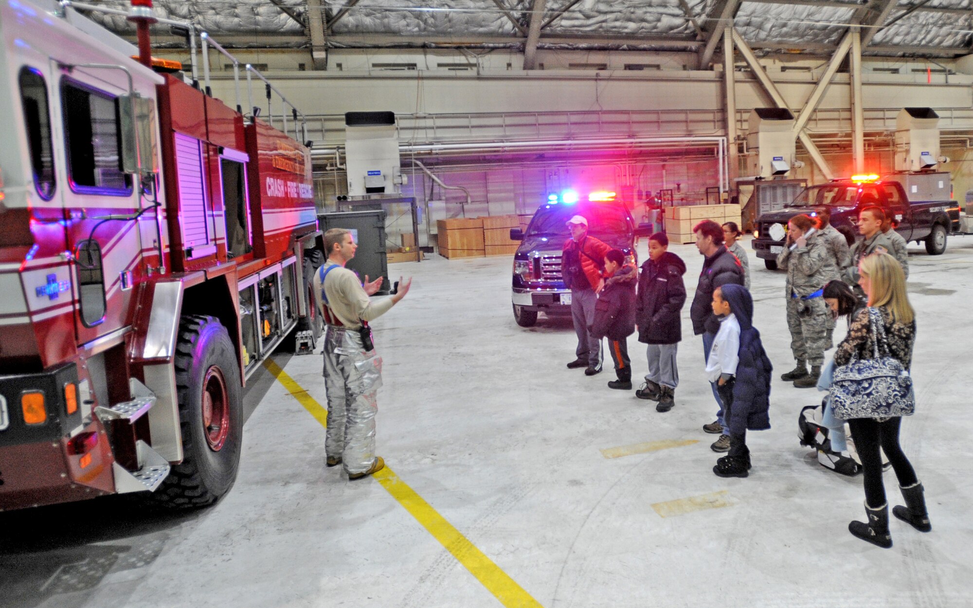 Air Force Staff Sgt. Greg Massma, 673d Civil Engineer Squadron, shows children the inner components and capabilities of a fire truck during the Joint Base Elmendorf-Richardson, Big Brothers Big Sisters tour, Feb. 18. With help from volunteers, BBBS provides children from single-parent homes who grow up in poverty and cope with parental incarceration, with role models. (U.S. Air Force photo/Senior Airman Laura Turner)