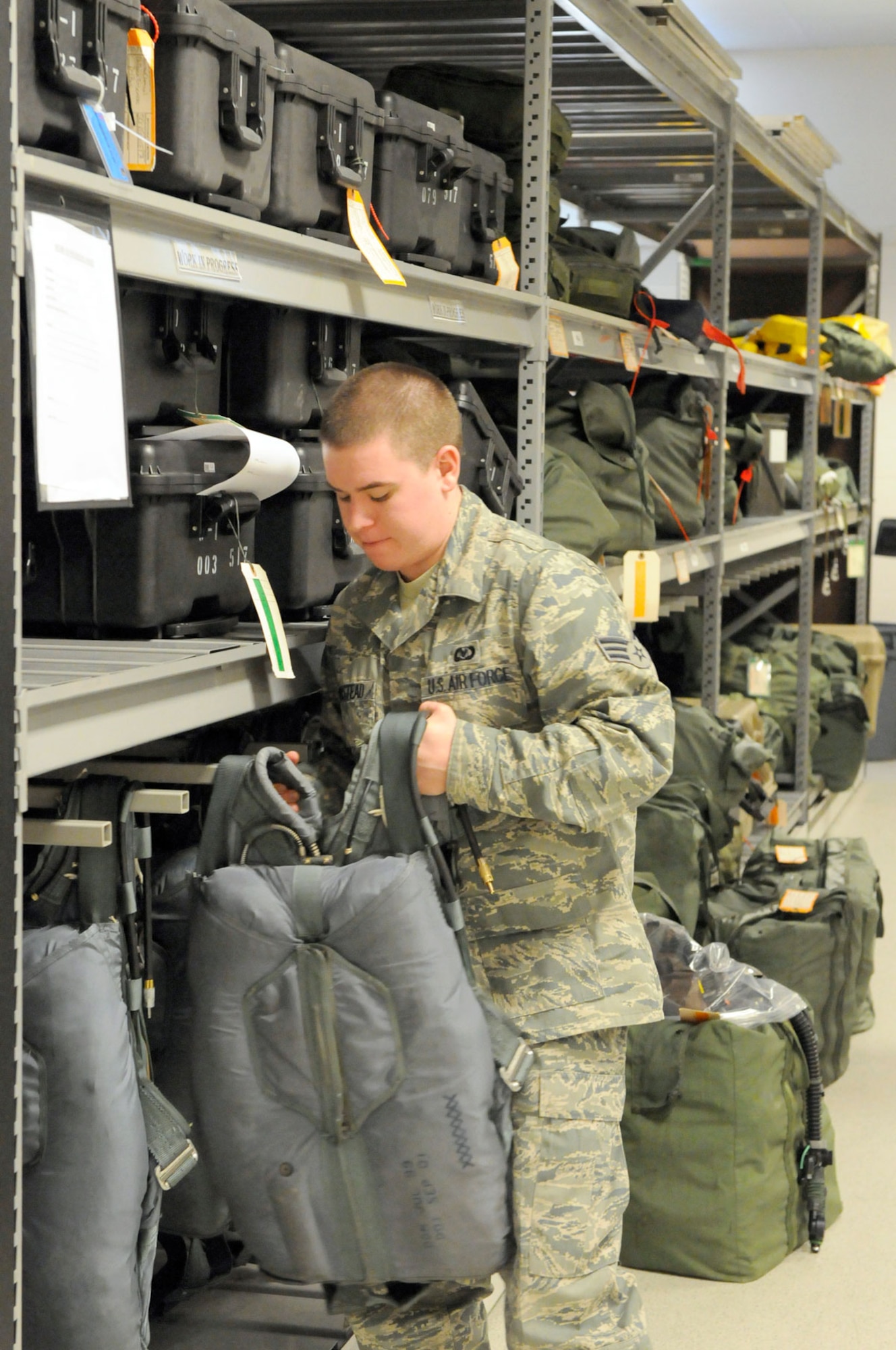 Senior Airman Anthony Boustead pulls a parachute for inspection. (U.S. Air Force photo/Steven White)