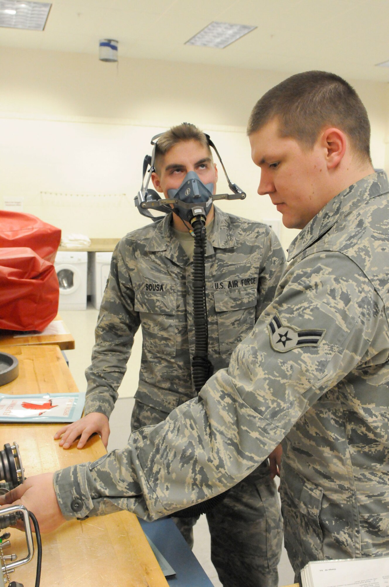 Airman 1st Class Nicholas Sousa wears a mask as Airman 1st Class Patrick Bell, tests the mask as part of 517th Airlift Squadron support. (U.S. Air Force photo/Steven White)