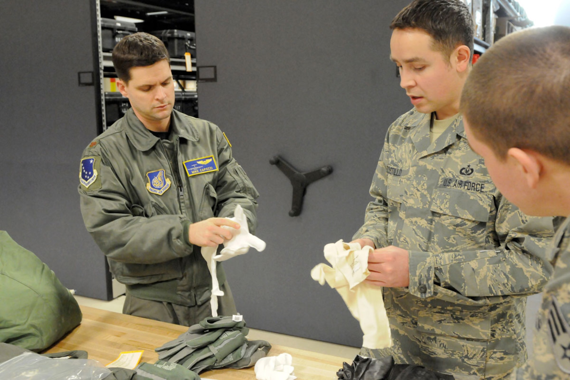 Air Force Maj. Mike Capozzi, 611th Operations Center, receives flight crew individual issue from Tech. Sgt. Ramiro Castillo, 517th Airlift Squadron at Joint Base Elmendorf-Richardson. (U.S. Air Force photo/Steven White)