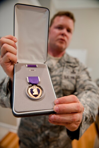 VALDOSTA, Ga. -- Master Sgt. Robert Disney, 347th Rescue Group standards and evaluations superintendent, shows off his Purple Heart Feb. 24 at his home. Sergeant Disney received the medal on May 1, 2003, for his actions during a deployment. (U.S. Air Force photo/Staff Sgt. Jamal D. Sutter)(RELEASED)