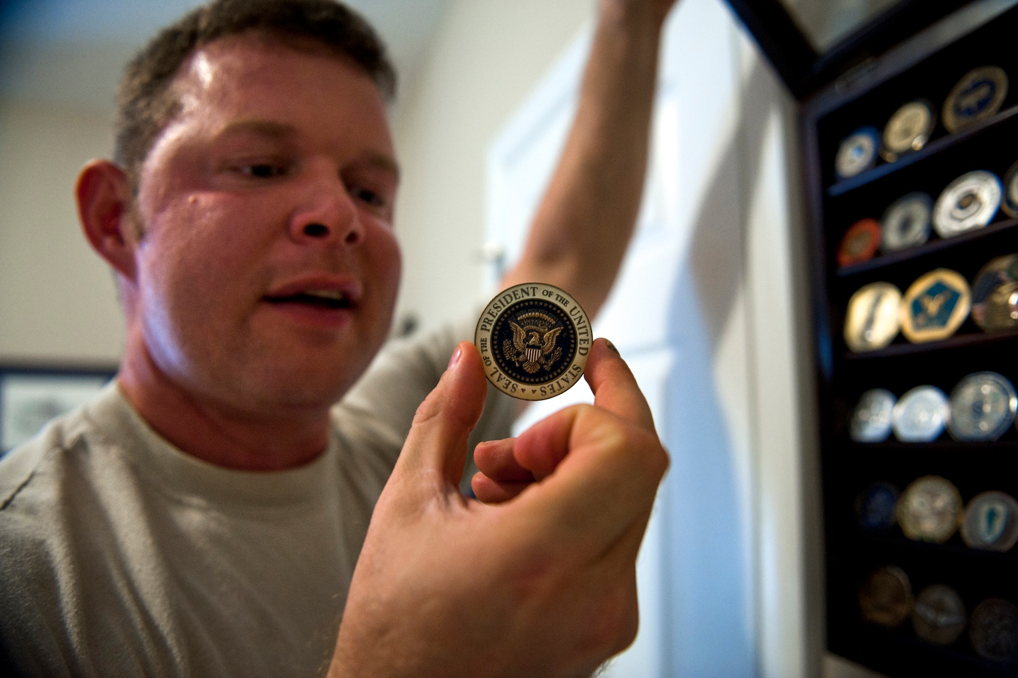VALDOSTA, Ga. -- Master Sgt. Robert Disney, a 14-year pararescueman assigned to the 347th Rescue Group, shows off a coin he received from former President George W. Bush at his home Feb. 24. Sergeant Disney earned it while performing personnel recovery alert for the president in 2004. During that time, he assisted the Secret Service in a medical capacity. (U.S. Air Force photo/Staff Sgt. Jamal D. Sutter)(RELEASED)