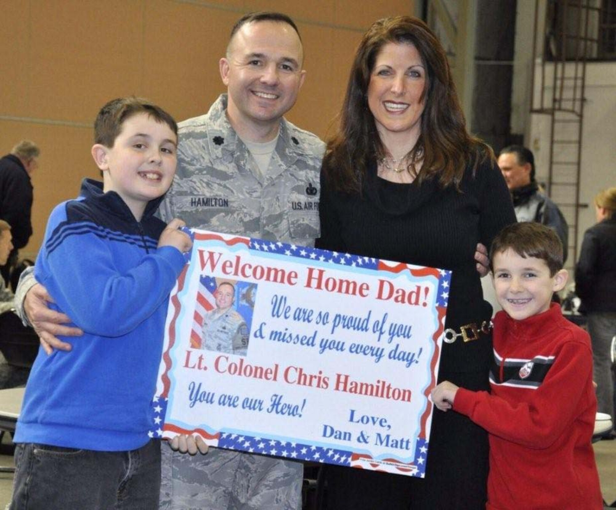 FALMOUTH, Mass. - Lt. Col. Christopher Hamilton, 102nd Security Forces Squadron Commander, received a warm "welcome home" from his wife, Leslie, and their sons,  Daniel and Matthew, at a ceremony at Otis Air National Guard Base. The 102nd Intelligence Wing of the Massachusetts Air National Guard honored 42 airmen from the 102nd Security Forces Squadron (SFS) upon their return home from their deployment to Iraq. The wing held a welcome home ceremony to honor them and their families on Tuesday, Feb. 22, 2011. The Airmen have received mobilization orders last year and were deployed to Iraq for six-months in support of Operation New Dawn. Their primary responsibilities were to provide security and air base defense operations.  This was the largest number of 102nd SFS Airmen to deploy at the same time since Sept. 11, 2001.  In addition, it was the first time the squadron's command staff deployed as a group. (U.S. Air Force Photo by Maj. Lisa Ahaesy, Massachusetts National Guard) 