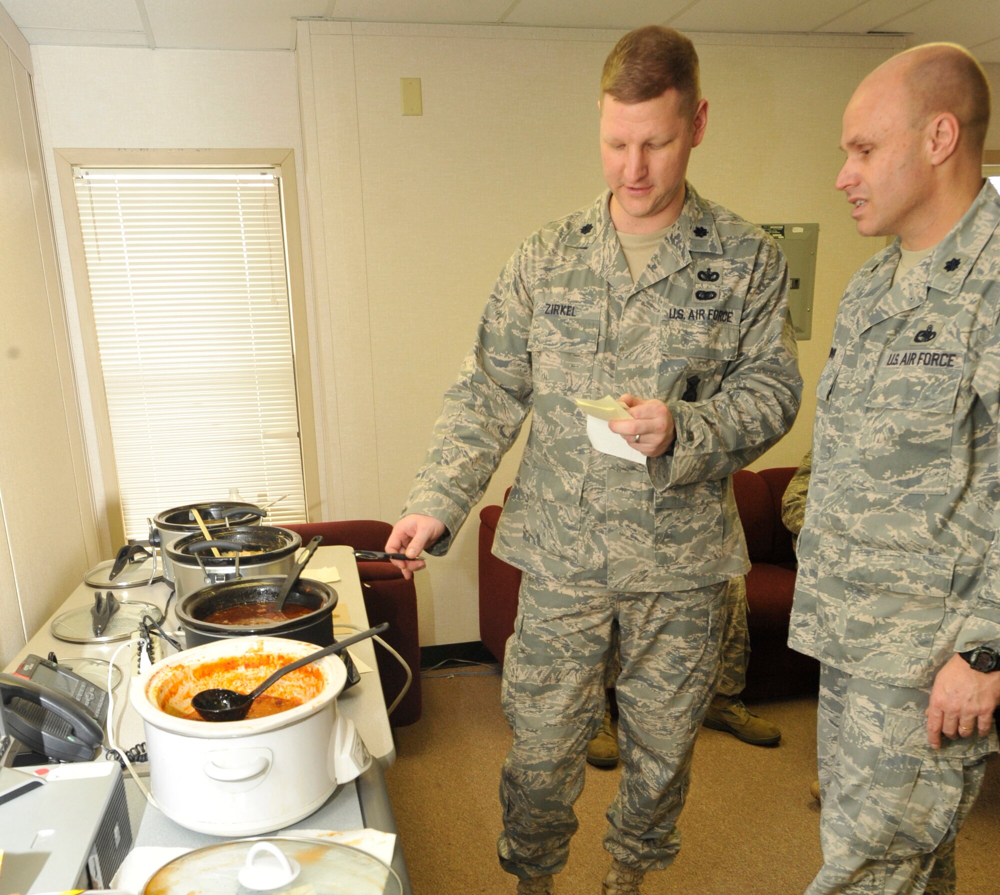 Lt. Col. James Zirkel, 436th Security Forces Squadron commander, and Lt. Col. Travis Condon, 436th Mission Support Group deputy commander, prepare to announce the winning entry at the 436 SFS chili cook-off during Wingman's Day, Feb. 25, 2011, at Dover Air Force Base, Del. 1st Lt. Justin Blair, 436 SFS officer in charge of logistics, took top prize with his homemade three-meat chili. (U.S. Air Force photos/Airman 1st Class Samuel Taylor)
