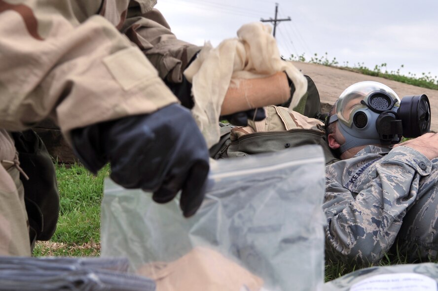 An Airman participating in the Ability to Survive and Operate Rodeo during the Conventional Operation Readiness Exercise searches through medical equipment while Staff Sgt. James Keammer, 2nd Operations Support Squadron, plays the role of a wounded Airman at the Warrior Center on Barksdale Air Force Base, La., Feb. 25. All Airmen are trained to perform self aid and buddy care which is the United States Air Force?s form of first aid. (U.S. Air Force photo/Airman 1st Class Micaiah Anthony) (RELEASED)  