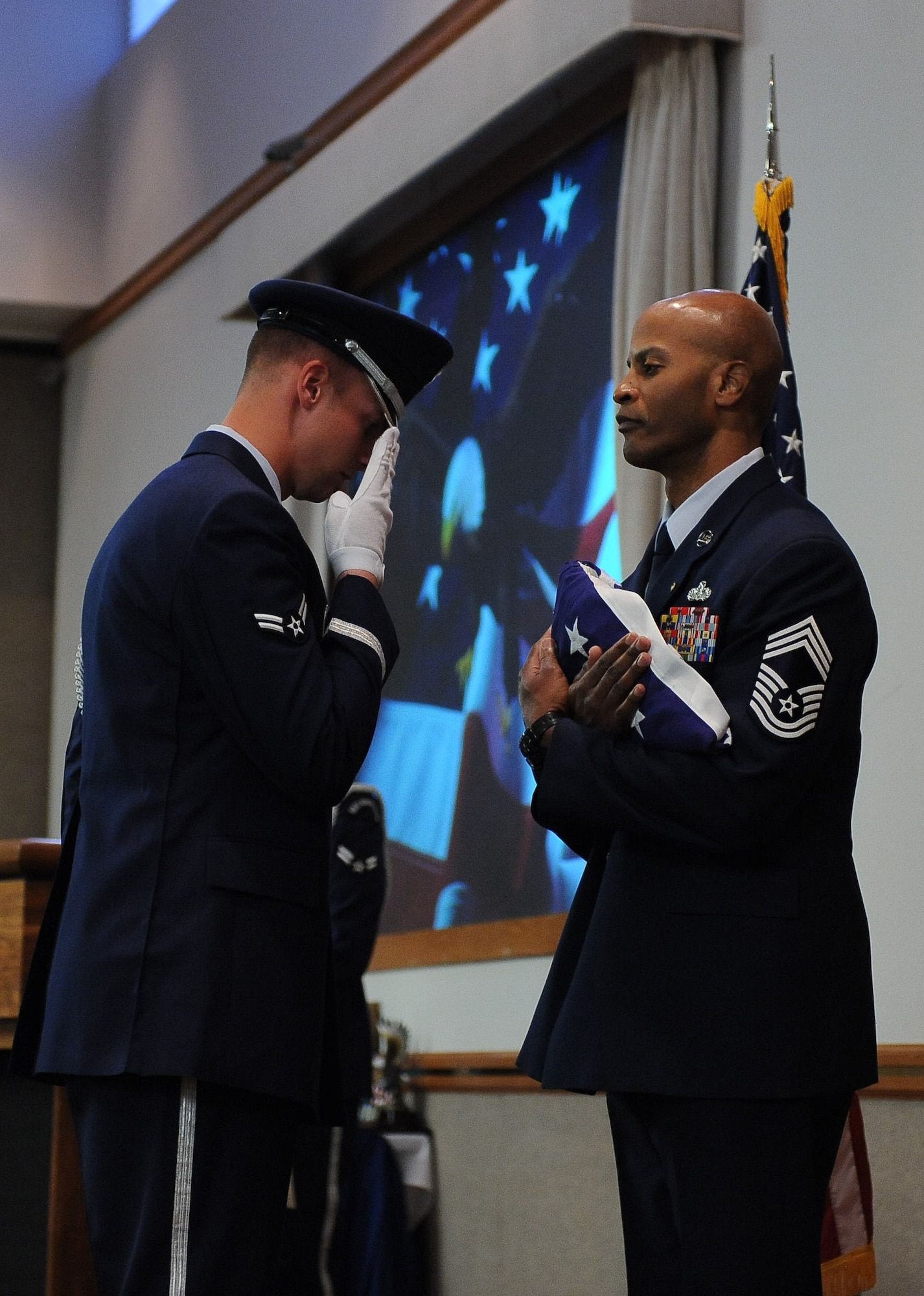 Airman 1st Class Lewis Hafner, Nellis Honor Guard, presents the flag to Chief Master Sgt. Mark Darden during the chief’s retirement ceremony at the Nellis Club Feb. 22. (U.S. Air Force photo by Senior Airman Stephanie Rubi)
