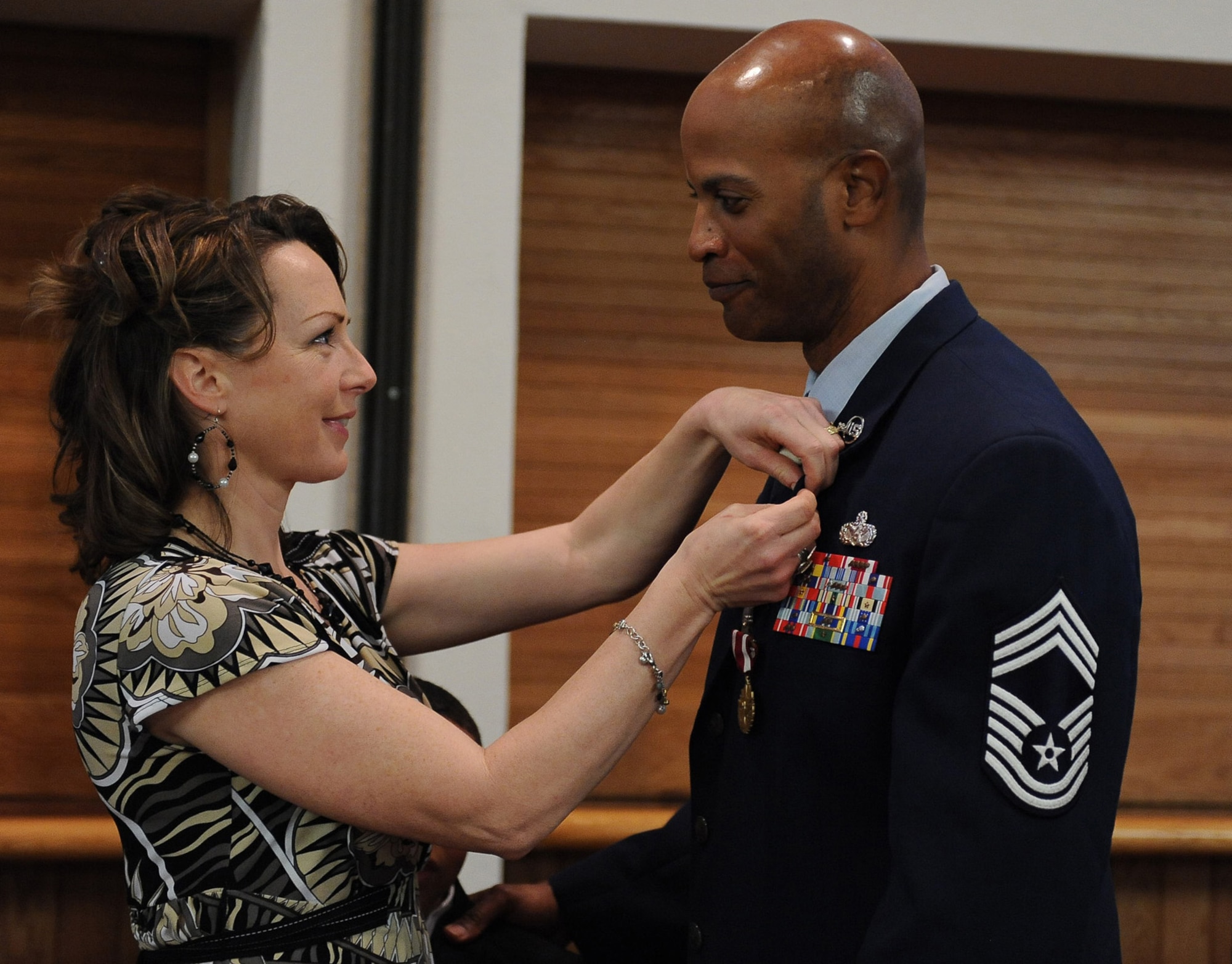 Laura Darden presents her husband, Chief Master Sgt. Mark Darden, with his retirement pin during the chief’s retirement ceremony at the Nellis Club Feb. 22. (U.S. Air Force photo by Senior Airman Stephanie Rubi)