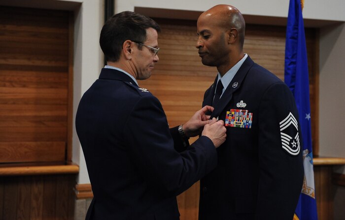 Col. John Montgomery, 98th Range Wing commander, presents Chief Master Sgt. Mark Darden with the Meritorious Service Medal during the chief’s retirement ceremony at the Nellis Club Feb. 22. (U.S. Air Force photo by Senior Airman Stephanie Rubi)