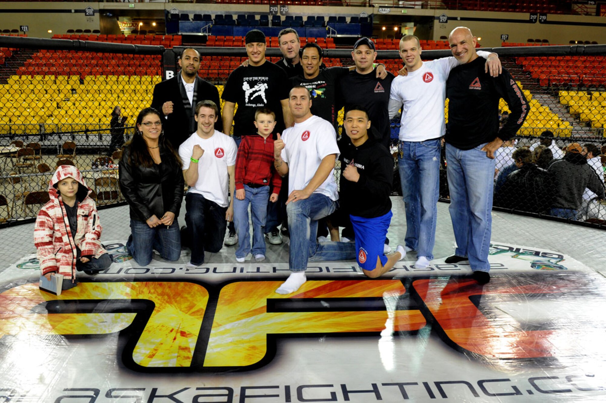 ANCHORAGE , Alaska -- Airman 1st Class Nojin “Ian” Park (bottom row far right), 3rd Maintenance Operation Squadron, poses with the rest of the Gracie Barra gym in the cage at the end of the Alaska Fighting Championship at the Anchorage Sullivan Arena, February 17. (U.S. Air Force Photo by Staff Sgt. Joshua Garcia)