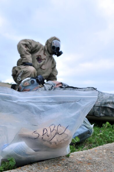 A bag with medical equipment used for self aid and buddy care sits in the grass while an Airman participating in the Ability to Survive and Operate Rodeo during the Conventional Operation Readiness Exercise waits for a medical team to arrive on Barksdale Air Force Base, La., Feb. 25. SABC training entails basic life saving skills. (U.S. Air Force photo/Airman 1st Class Micaiah Anthony)( RELEASED)   