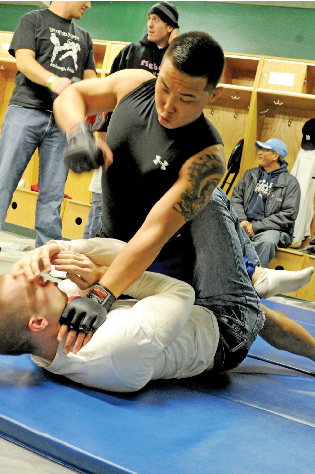Airman 1st Class Nojin Park, 3rd MOS, practices “ground and pound” technique with Joe Murphy, of Gracie Barra, prior to his debut match at the Anchorage Sullivan Arena, Feb. 17.  (U.S. Air Force photo/Staff Sgt. Joshua Garcia)