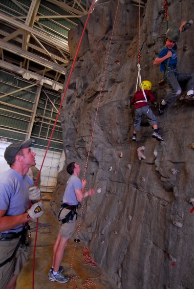 Pararescuemen from the 31st Rescue Squadron assist children climbing the 40-foot rock wall during Rescue Fest at the 31st RQS, Feb. 26. Pararescuemen demonstrated their skills and capabilities to the more than 1,000 guests attending the event through multiple static displays, live-action rescue simulations and numerous other activities like the rock wall and parachute simulator. (U.S. Air Force photo/ Airman 1st Class Maeson L. Elleman)