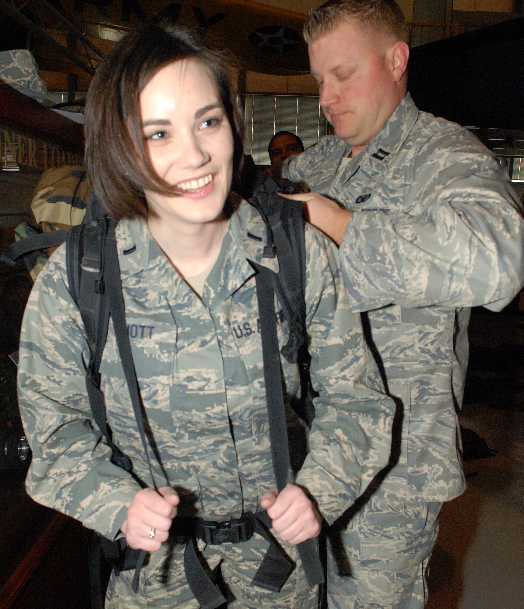 Capt. Erik Deshane, 436th Security Forces Squadron operations officer, helps 1st Lt. Amanda Elliott, 436th Mission Support Group executive officer, strap on her rucksack, Feb. 26 2011, during the 12th Annual Ruck March at the Airlift Mobility Command museum, Dover Air Force Base, Del.  