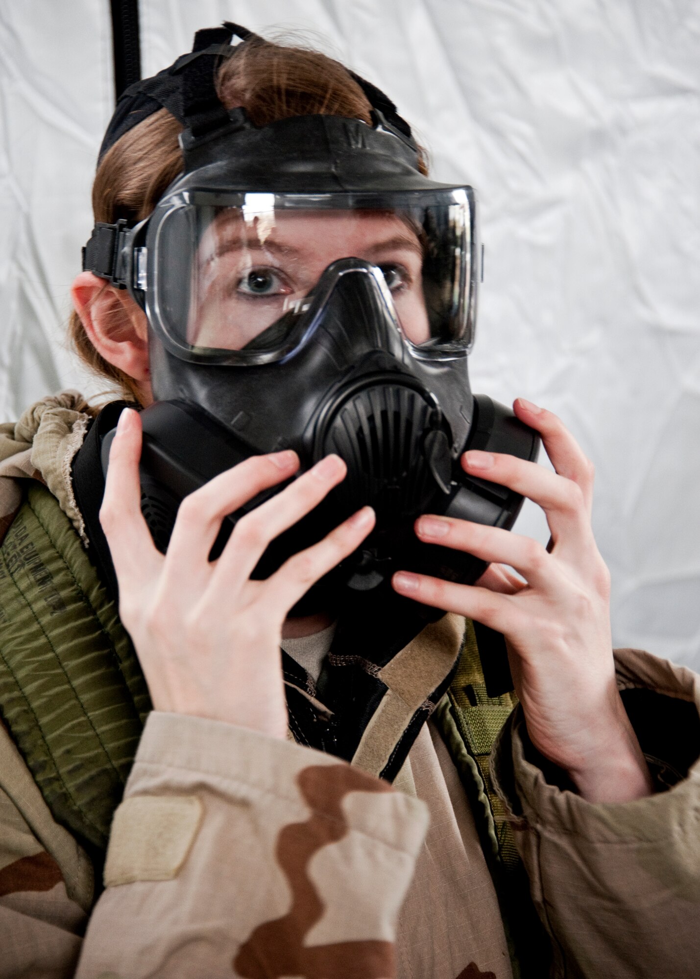 Airman 1st Class Kasandra Wood, 96th Force Support Squadron, dons her M-50 gas mask during the Phase II exercise Feb. 24 at Eglin Air Force Base, Fla.  Phase II included self-aid and buddy care, weapons, and chemical, biological, radiological, nuclear and explosive training.  Airmen learned the proper procedures for self-aid and buddy care, field stripping a weapon and also how to wear and work in their chemical gear and gas masks.  Three chalks of Eglin Airmen participated in Phase I and II exercises as part of an Operational Readiness Exercise throughout the week of Feb. 22-25.  (U.S. Air Force photo/Samuel King Jr.)