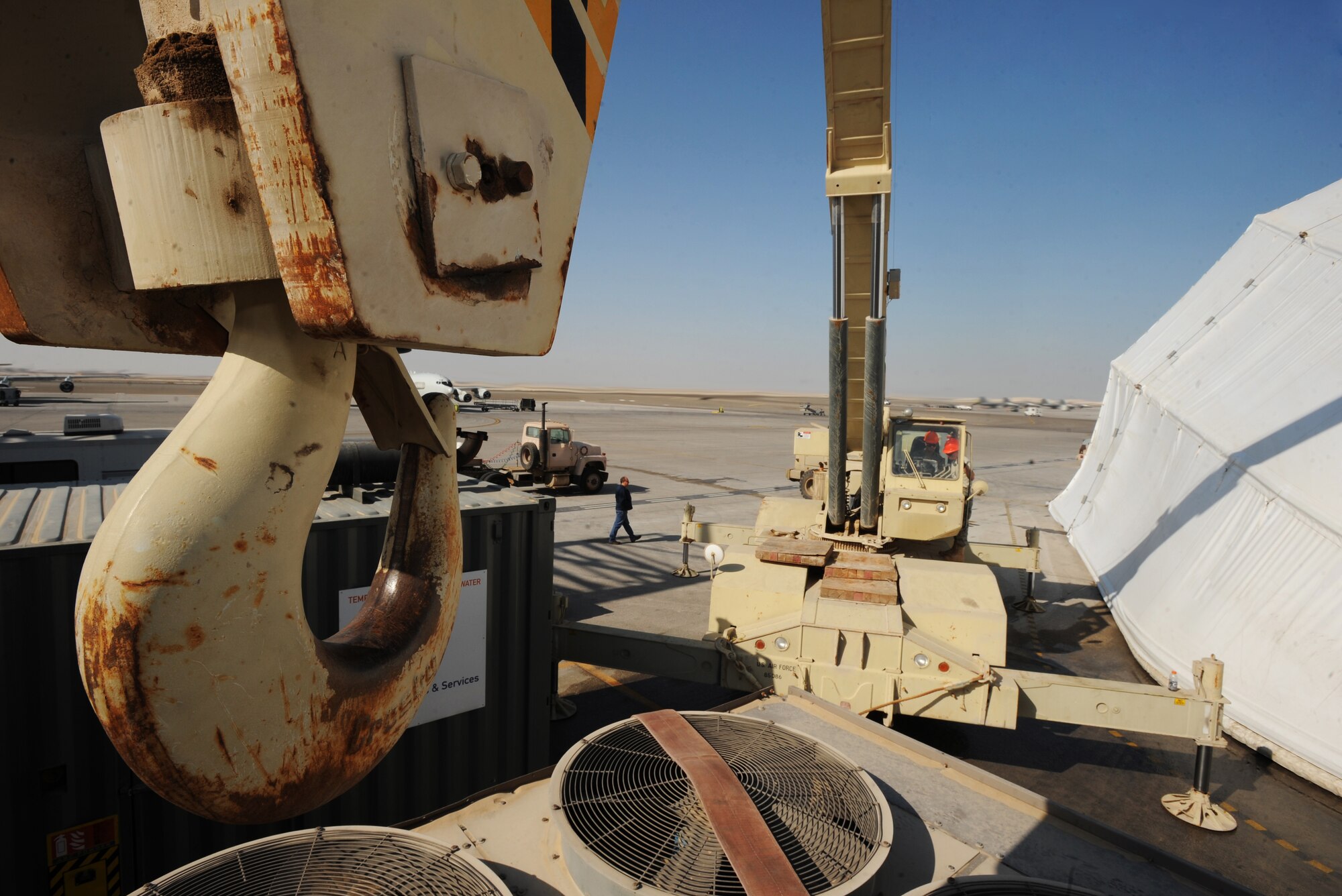 Senior Airman Steven Chalupnik, 380th Expeditionary Civil Engineer Squadron, uses a 60-ton crane to move cooling units and generators Feb 8, 2011. Moving the generators makes way for new tents. (U.S. Air Force photo by Senior Airman Maynelinne De La Cruz) 