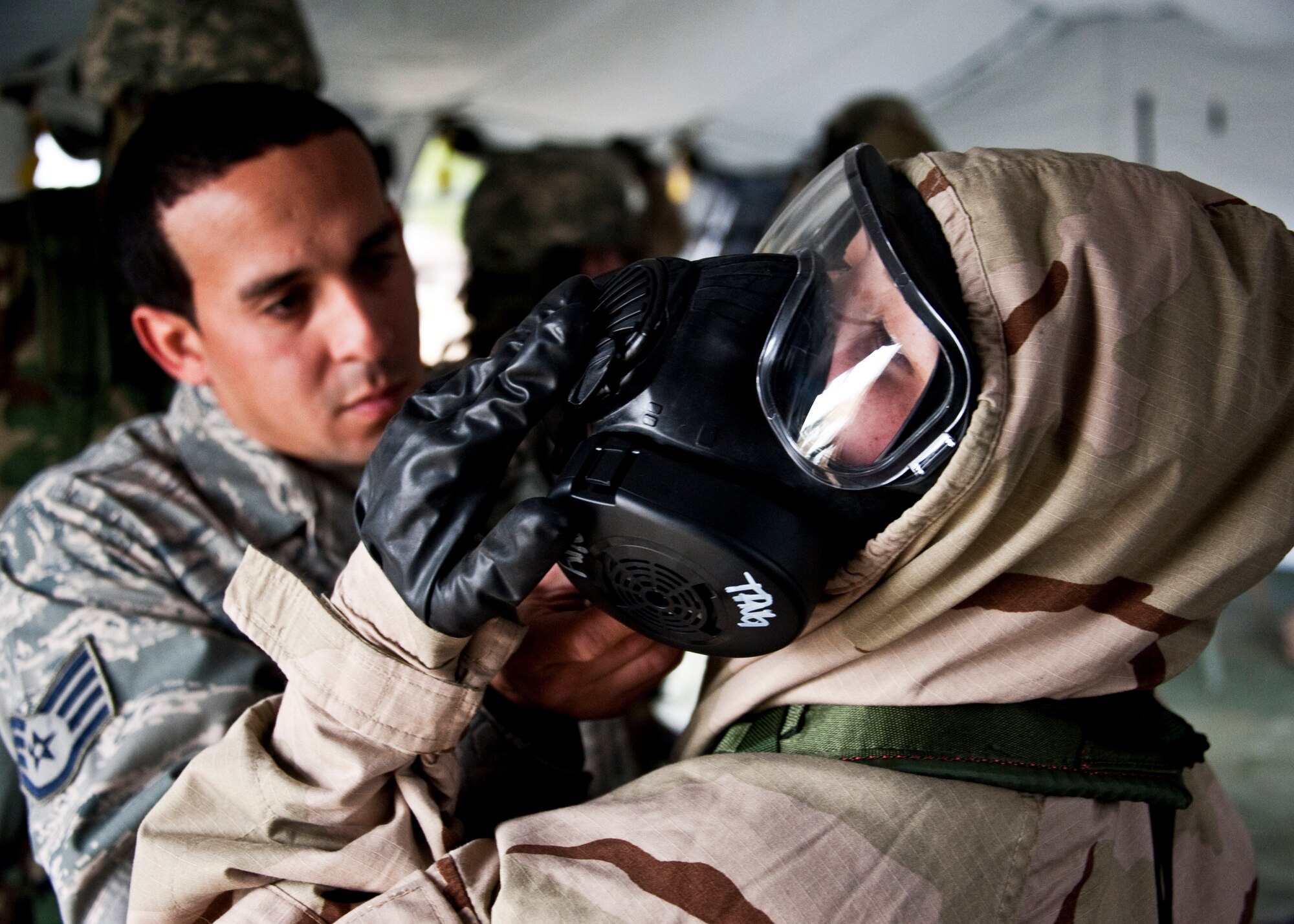 Staff Sgt. Peter Torres, 96th Civil Engineer Squadron, ensures an Airman’s chemical suit is sealed and secured during the Phase II exercise Feb. 24 at Eglin Air Force Base, Fla.  Phase II included self-aid and buddy care, weapons, and chemical, biological, radiological, nuclear and explosive training.  Airmen learned the proper procedures for self-aid and buddy care, field stripping a weapon and also how to wear and work in their chemical gear and gas masks.  Three chalks of Eglin Airmen participated in Phase I and II exercises as part of an Operational Readiness Exercise throughout the week of Feb. 22-25.  (U.S. Air Force photo/Samuel King Jr.)