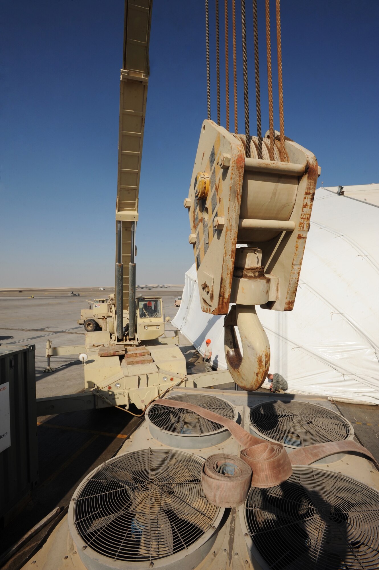 Senior Airman Steven Chalupnik, 380th Expeditionary Civil Engineer Squadron, uses a 60-ton crane to move cooling units and generators Feb 8, 2011. Moving the generators makes way for new tents. (U.S. Air Force photo by Senior Airman Maynelinne De La Cruz) 