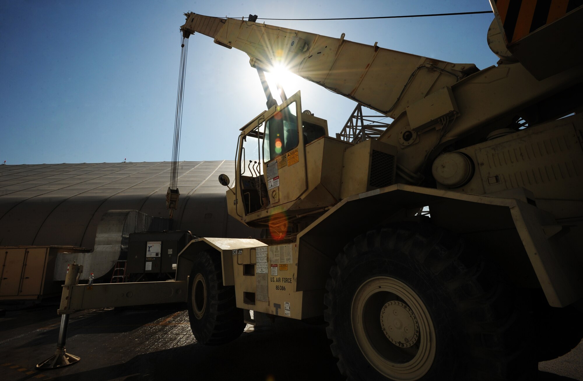 Senior Airman Steven Chalupnik, 380th Expeditionary Civil Engineer Squadron, uses a 60-ton crane to move cooling units and generators Feb 8, 2011. Moving the generators makes way for new tents. (U.S. Air Force photo by Senior Airman Maynelinne De La Cruz) 