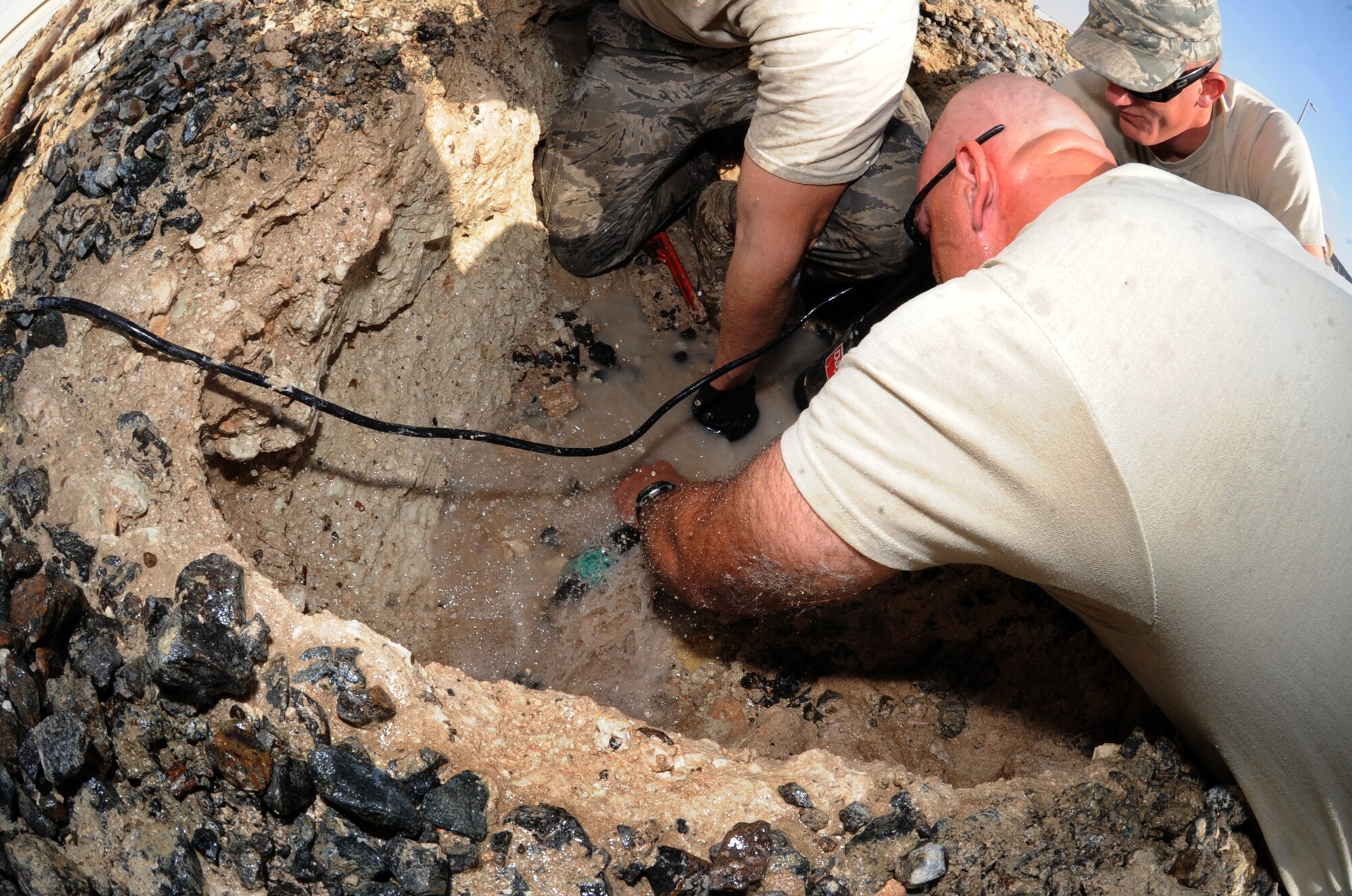 Tech Sgt. George Burns, 380th Expeditionary Civil Engineer Squadron, tries to fix a water main break near Windy's Feb. 7, 2011, in Southwest Asia. Water main breaks are common as the ground randomly shifts, affecting pipes around it. Sergeant Burns is deployed from the 341st CES out of Malstrom AFB, Mont . (U.S. Air Force photo by Senior Airman Maynelinne De La Cruz)