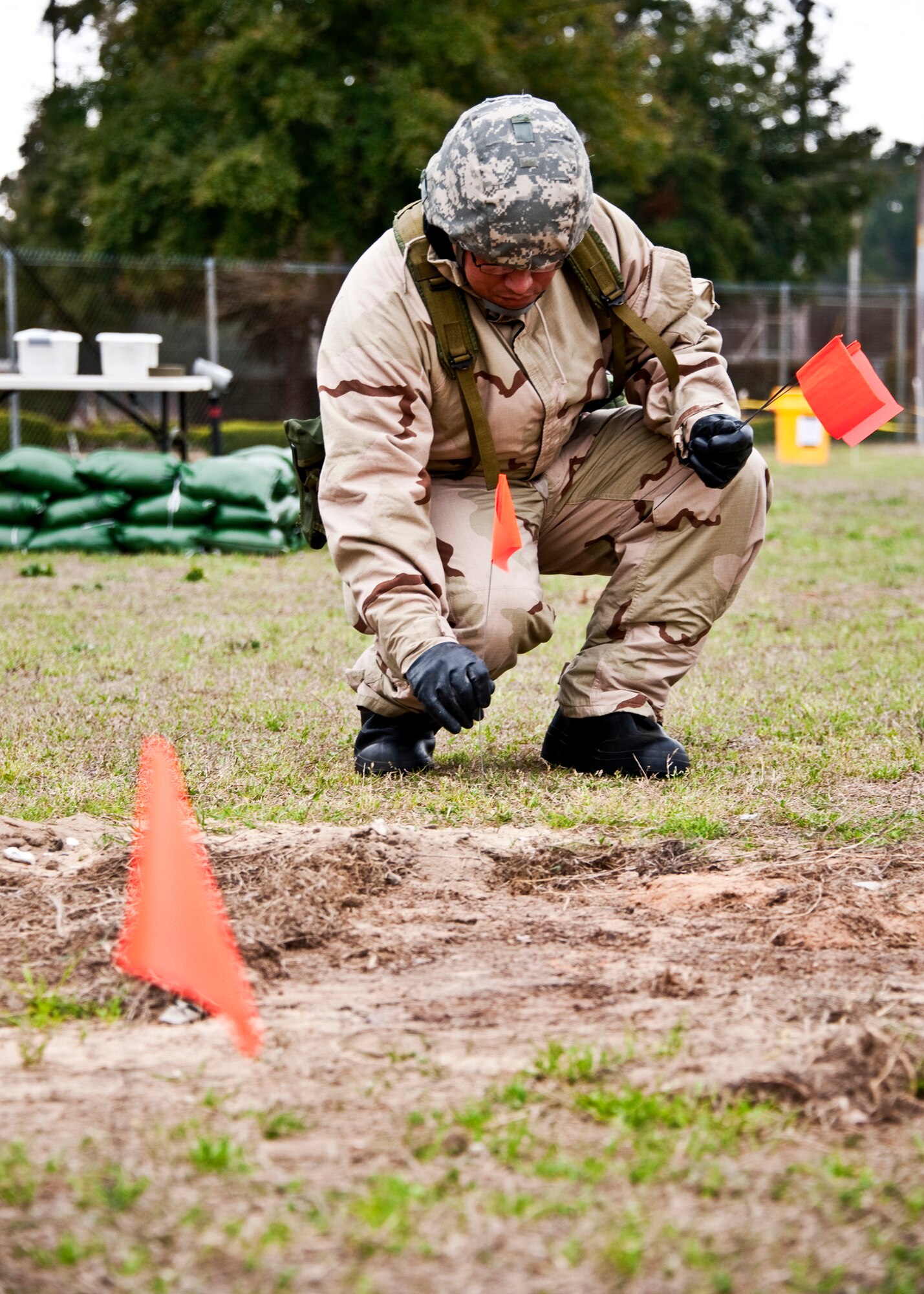 An Airman places a flag down to mark the area around an unexploded ordnance during the Phase II exercise Feb. 24 at Eglin Air Force Base, Fla.  Phase II included self-aid and buddy care, weapons, and chemical, biological, radiological, nuclear and explosive training.  Airmen learned the proper procedures for self-aid and buddy care, field stripping a weapon and also how to wear and work in their chemical gear and gas masks.  Three chalks of Eglin Airmen participated in Phase I and II exercises as part of an Operational Readiness Exercise throughout the week of Feb. 22-25.  (U.S. Air Force photo/Samuel King Jr.)