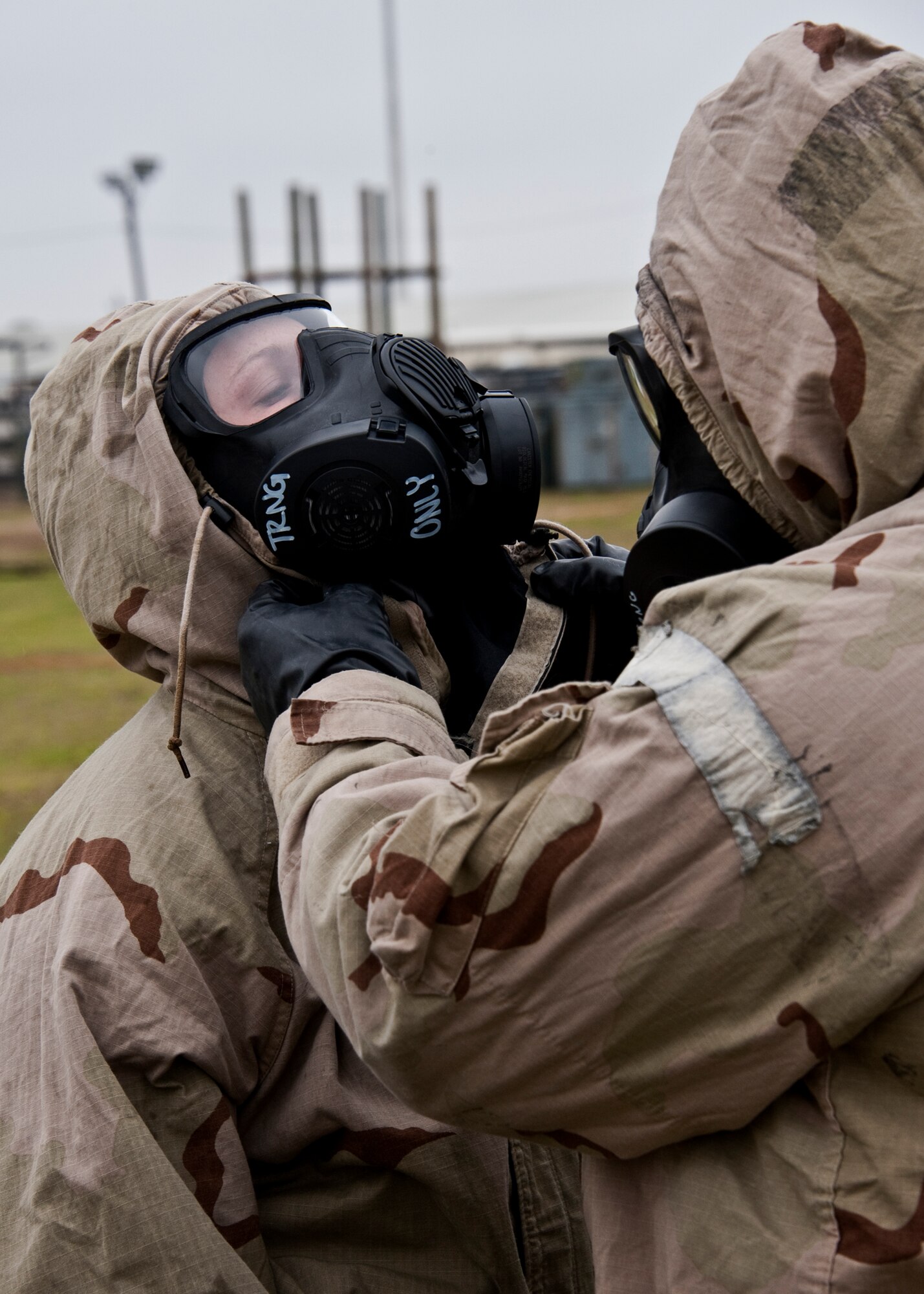 An Airman assists his wingman with sealing up her chemical suit during the Phase II exercise Feb. 24 at Eglin Air Force Base, Fla.  Phase II included self-aid and buddy care, weapons, and chemical, biological, radiological, nuclear and explosive training.  Airmen learned the proper procedures for self-aid and buddy care, field stripping a weapon and also how to wear and work in their chemical gear and gas masks.  Three chalks of Eglin Airmen participated in Phase I and II exercises as part of an Operational Readiness Exercise throughout the week of Feb. 22-25.  (U.S. Air Force photo/Samuel King Jr.)
