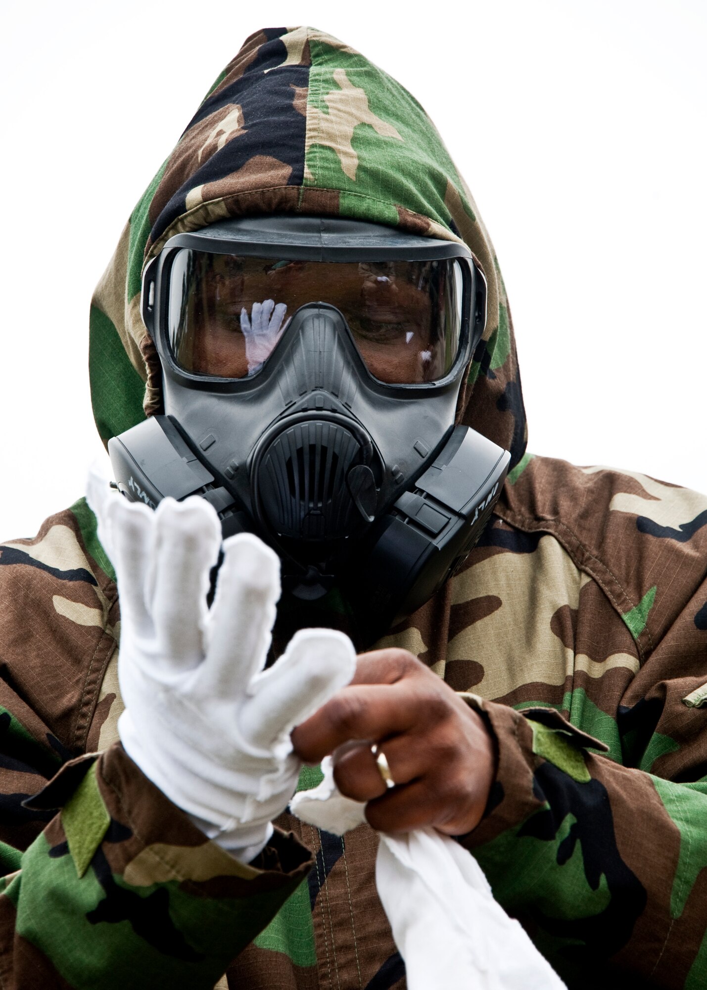 An Airman places the cloth inner glove on before donning the rubber outer glove during the Phase II exercise Feb. 24 at Eglin Air Force Base, Fla.  Phase II included self-aid and buddy care, weapons, and chemical, biological, radiological, nuclear and explosive training.  Airmen learned the proper procedures for self-aid and buddy care, field stripping a weapon and also how to wear and work in their chemical gear and gas masks.  Three chalks of Eglin Airmen participated in Phase I and II exercises as part of an Operational Readiness Exercise throughout the week of Feb. 22-25.  (U.S. Air Force photo/Samuel King Jr.)