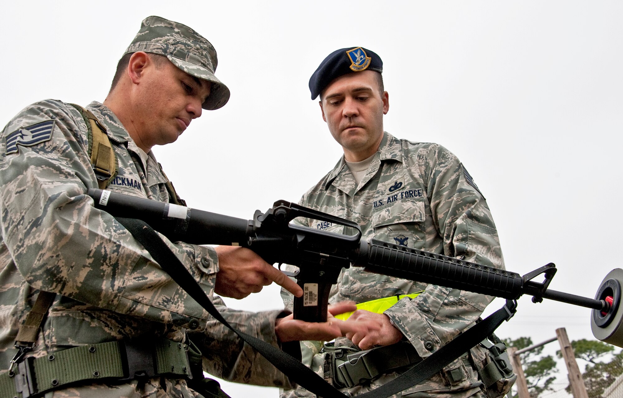 Staff Sgt. James Hickman, 96th Civil Engineer Squadron, pops the magazine into his weapon while Tech. Sgt. Josh Casey, 96th Security Forces Squadron, ensures the he follows procedures during the Phase II exercise Feb. 24 at Eglin Air Force Base, Fla.  Airmen learned the proper procedures for self-aid and buddy care, field stripping a weapon and also how to wear and work in their chemical gear and gas masks.  Three chalks of Eglin Airmen participated in Phase I and II exercises as part of an Operational Readiness Exercise throughout the week of Feb. 22-25.  (U.S. Air Force photo/Samuel King Jr.)