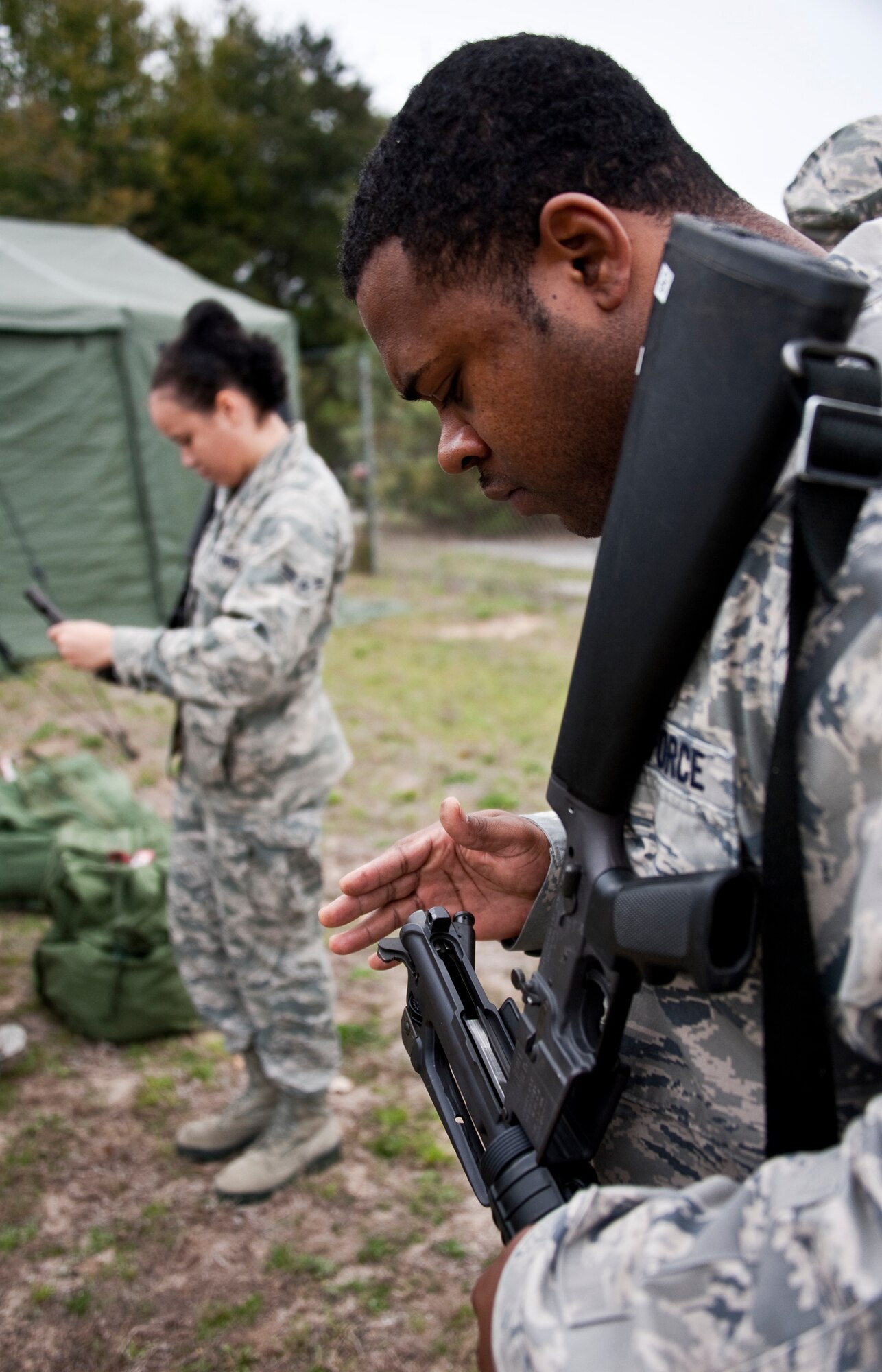 Staff Sgt. Terence Walker, 96th Force Support Squadron, and Airman 1st Class McKenzie Young, 96th Medical Operations Squadron, familiarize themselves with their weapons during the Phase II exercise Feb. 24 at Eglin Air Force Base, Fla.  Phase II included self-aid and buddy care, weapons, and chemical, biological, radiological, nuclear and explosive training.  Airmen learned the proper procedures for self-aid and buddy care, field stripping a weapon and also how to wear and work in their chemical gear and gas masks.  Three chalks of Eglin Airmen participated in Phase I and II exercises as part of an Operational Readiness Exercise throughout the week of Feb. 22-25.  (U.S. Air Force photo/Samuel King Jr.)