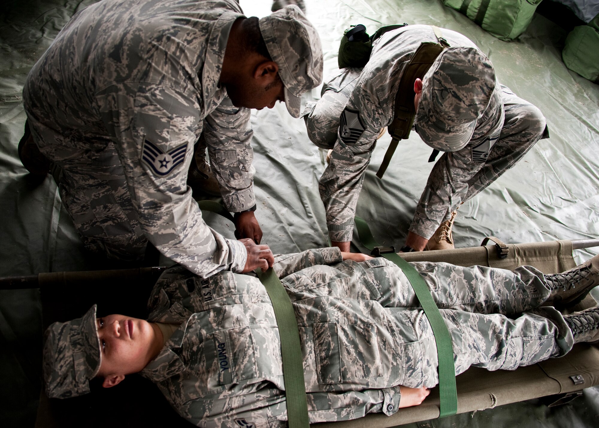 Airmen from the 96th Air Base Wing practice securing the patient during self-aid and buddy care training at the Phase II exercise Feb. 24 at Eglin Air Force Base, Fla.  Phase II included self-aid and buddy care, weapons, and chemical, biological, radiological, nuclear and explosive training.  Airmen learned the proper procedures for cleaning and loading their weapons and also how to wear and work in their chemical gear and gas masks.  Three chalks of Eglin Airmen participated in Phase I and II exercises as part of an Operational Readiness Exercise throughout the week of Feb. 22-25.  (U.S. Air Force photo/Samuel King Jr.)