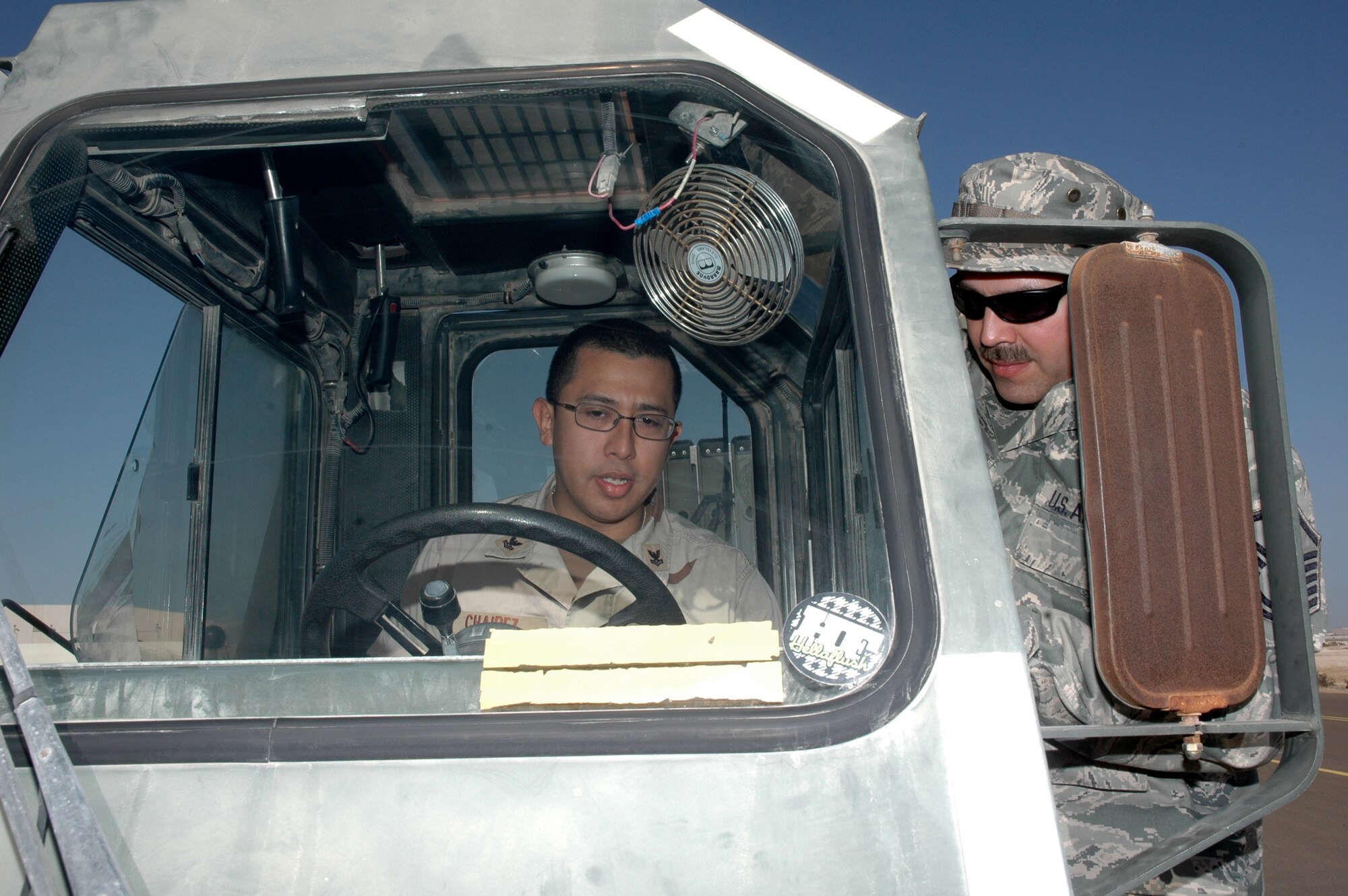 PO2 Joel Charez, Logistics Specialist, receives his 25k loader training from Master Sgt. Brian O'Daniel, 380th Expeditionary Logistics Readiness Squadron. Five U.S. Navy personnel from Camp Mirage benefited from the Air Force?s knowledge on heavy loading equipment operations recently. Using a 25k loader and forklift from the 380th Expeditionary Logistics Readiness Squadron at the Air Terminal Operations Center, the Airmen certified these Sailors to use this same type of equipment at their home station. This training will allow the Sailors to complete their mission which was at a work stoppage due to a non-certification. (U.S. Air Force photo by Master Sgt. Julie Briden-Garcia)