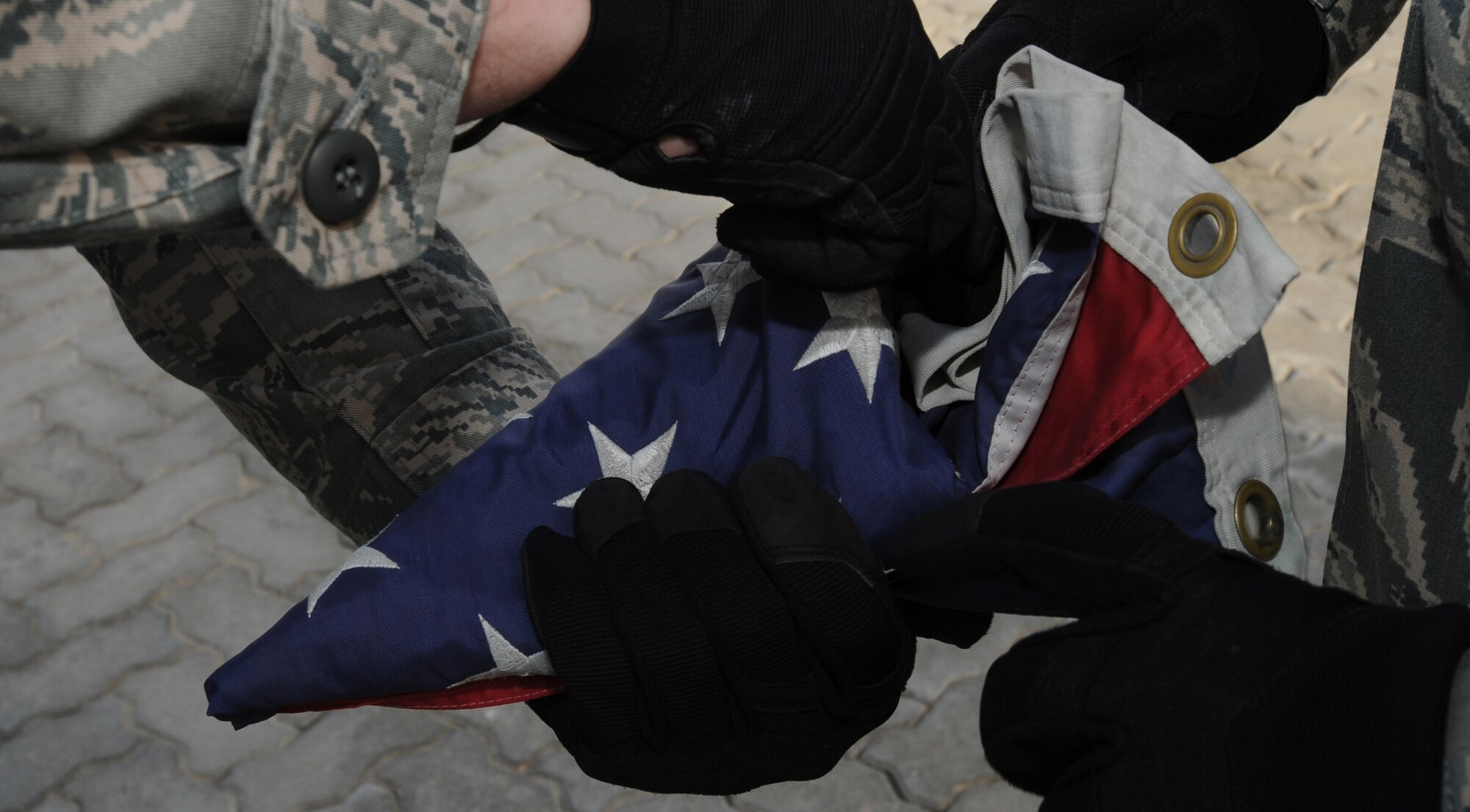Airman 1st Class Alec Krabbe, 380th Expeditionary Communications Squadron, folds and secures the American Flag while Senior Airman David Hunt, 380th Expeditionary Civil Engineer Squadron, holds it steady Feb 5, 2011 in Southwest Asia. The retreat ceremony signals the end of the official duty day and serves as a ceremony to pay our respects to the flag. Airman Krabbe is deployed from the 633rd CS, Langley AFB, Virginia; Airman Hunt is deployed from the 27th Special Operations CES, Cannon AFB, New Mexico. (U.S. Air Force photo by Senior Airman Maynelinne De La Cruz)